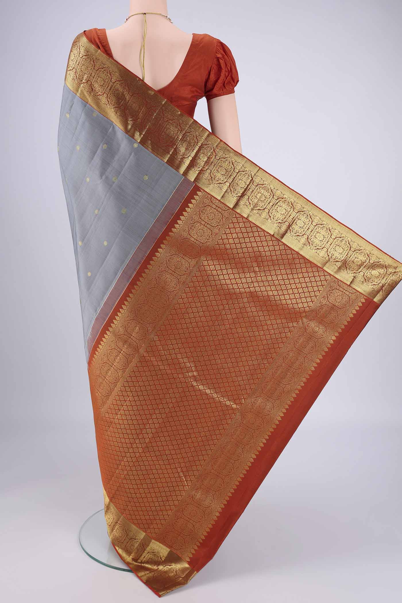 Flat view of Grey Kanchipuram Silk Saree with Zari Butta on the body and Zari Border. 