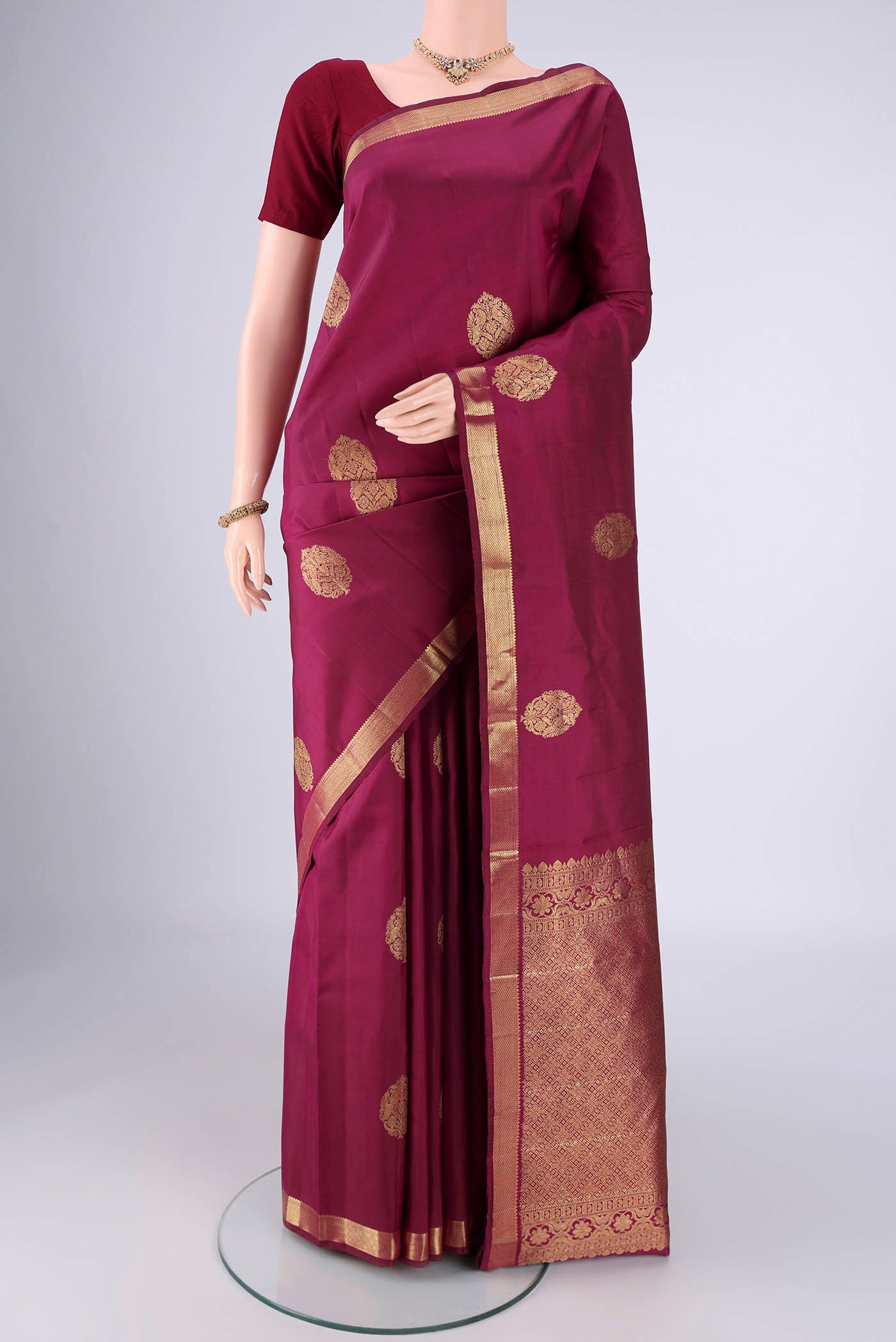 Pure Silk Pure Zari Magenta Kanchipuram Saree with Zari Butta on the body and Zari Border.  displayed on a mannequin