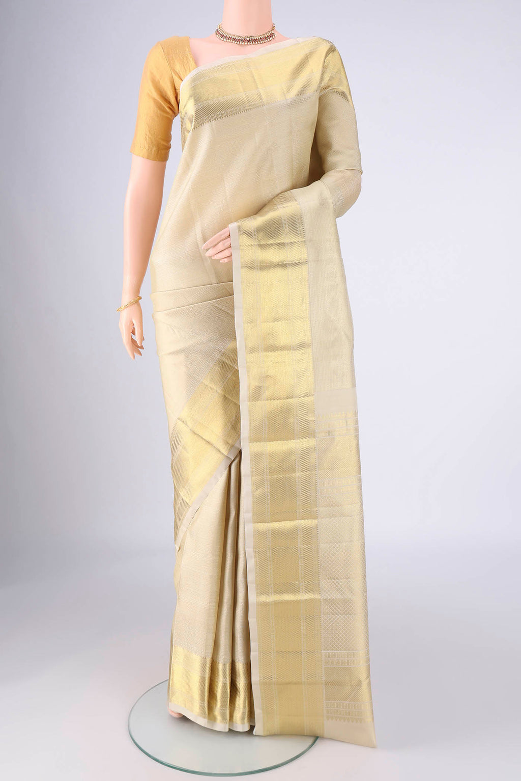 Off White Kanjivaram Silk Saree with Jacquard design on the body and Zari Border.  displayed on a mannequin