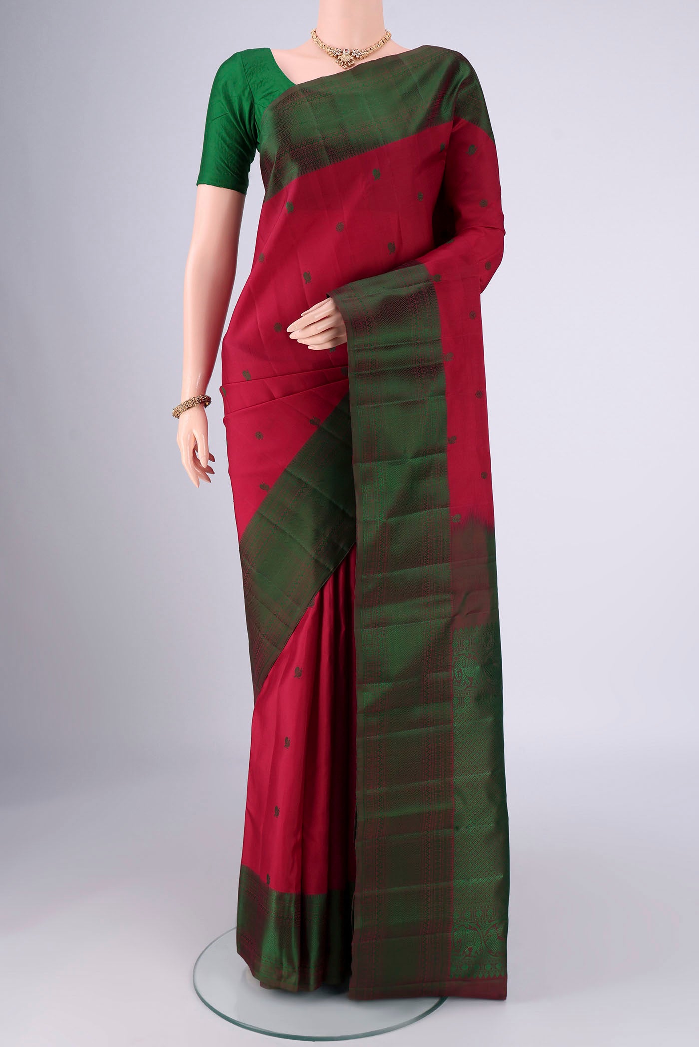 Maroon Kanchipuram Silk Saree with Thread Butta on the body and Thread Border.  displayed on a mannequin