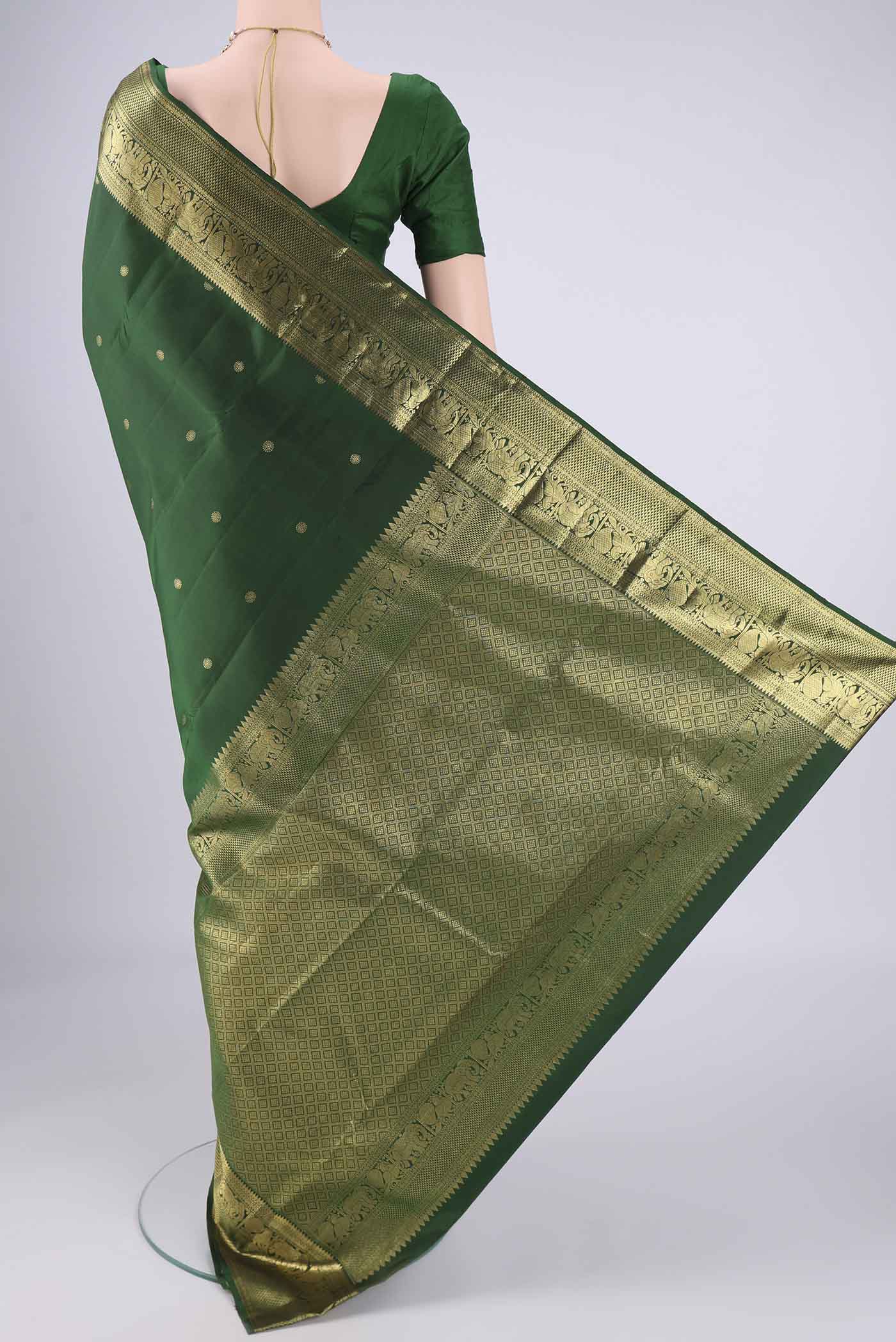 Flat view of Bottle Green Kanchipuram Saree with Zari Butta on the body and Zari Border. 