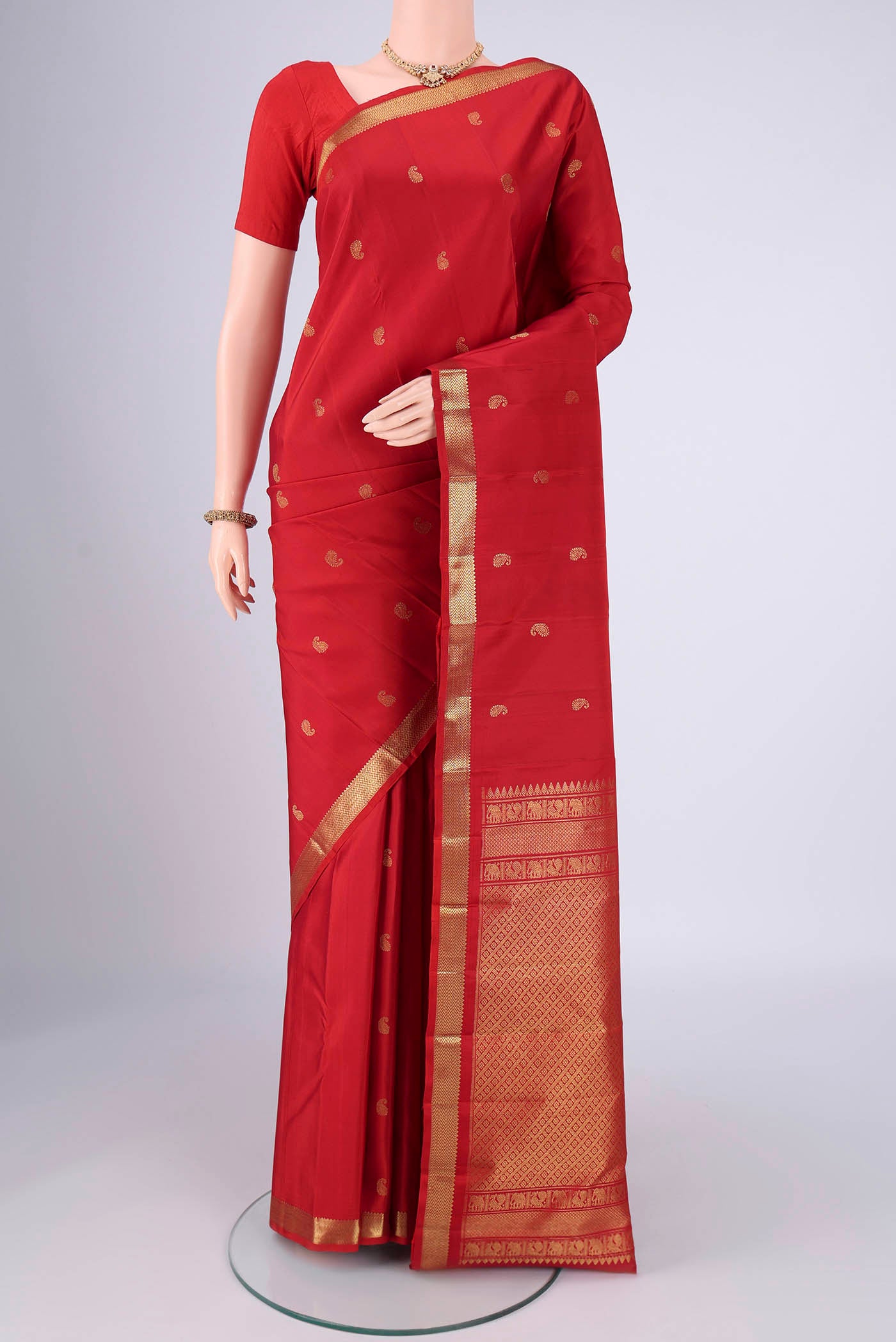 Pure Silk Pure Zari Red Kanchipuram Saree with Zari Butta on the body and Zari Border.  displayed on a mannequin