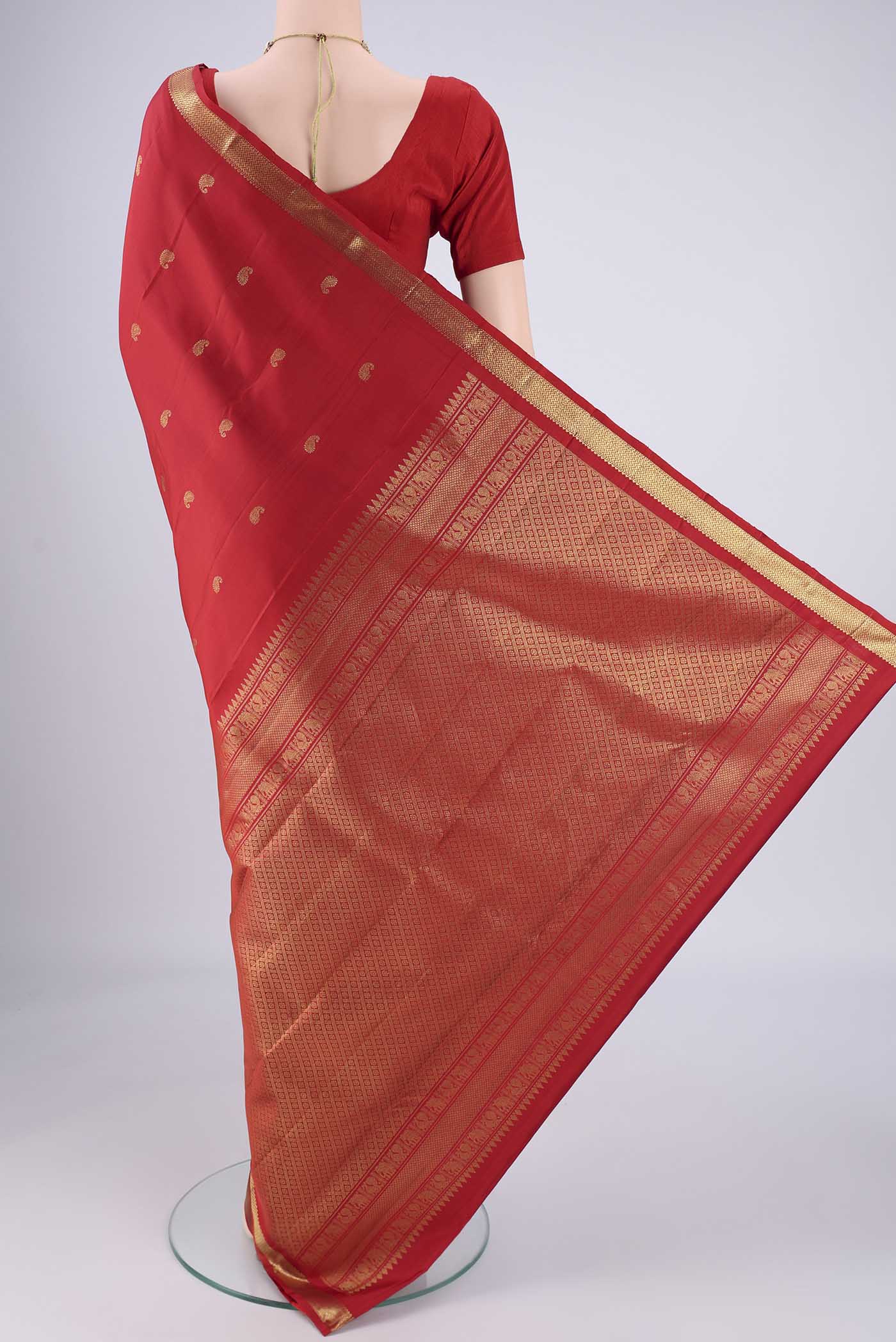 Flat view of Pure Silk Pure Zari Red Kanchipuram Saree with Zari Butta on the body and Zari Border. 