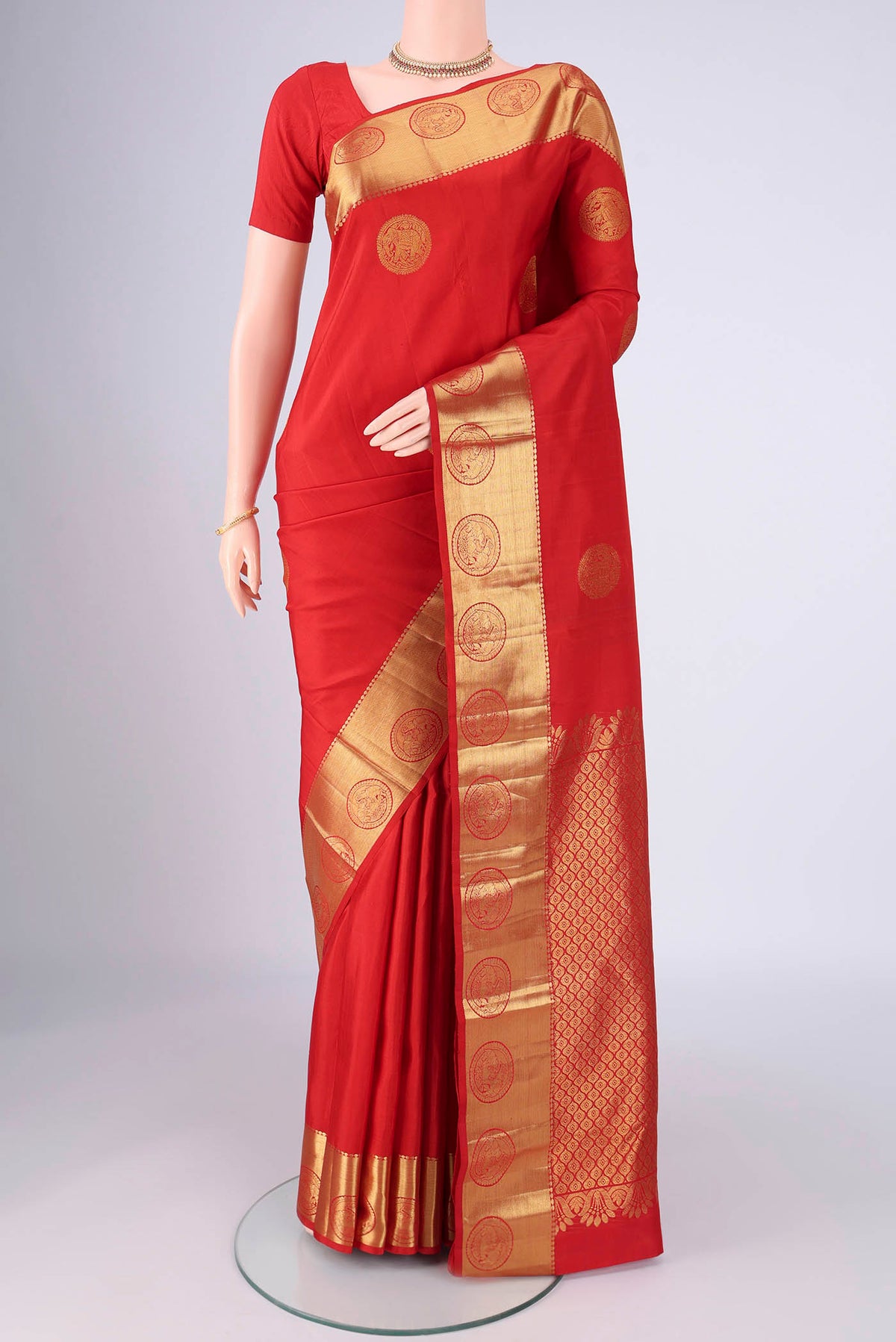 Red Kanchipuram Silk Saree with Zari Butta on the body and Zari Border.  displayed on a mannequin