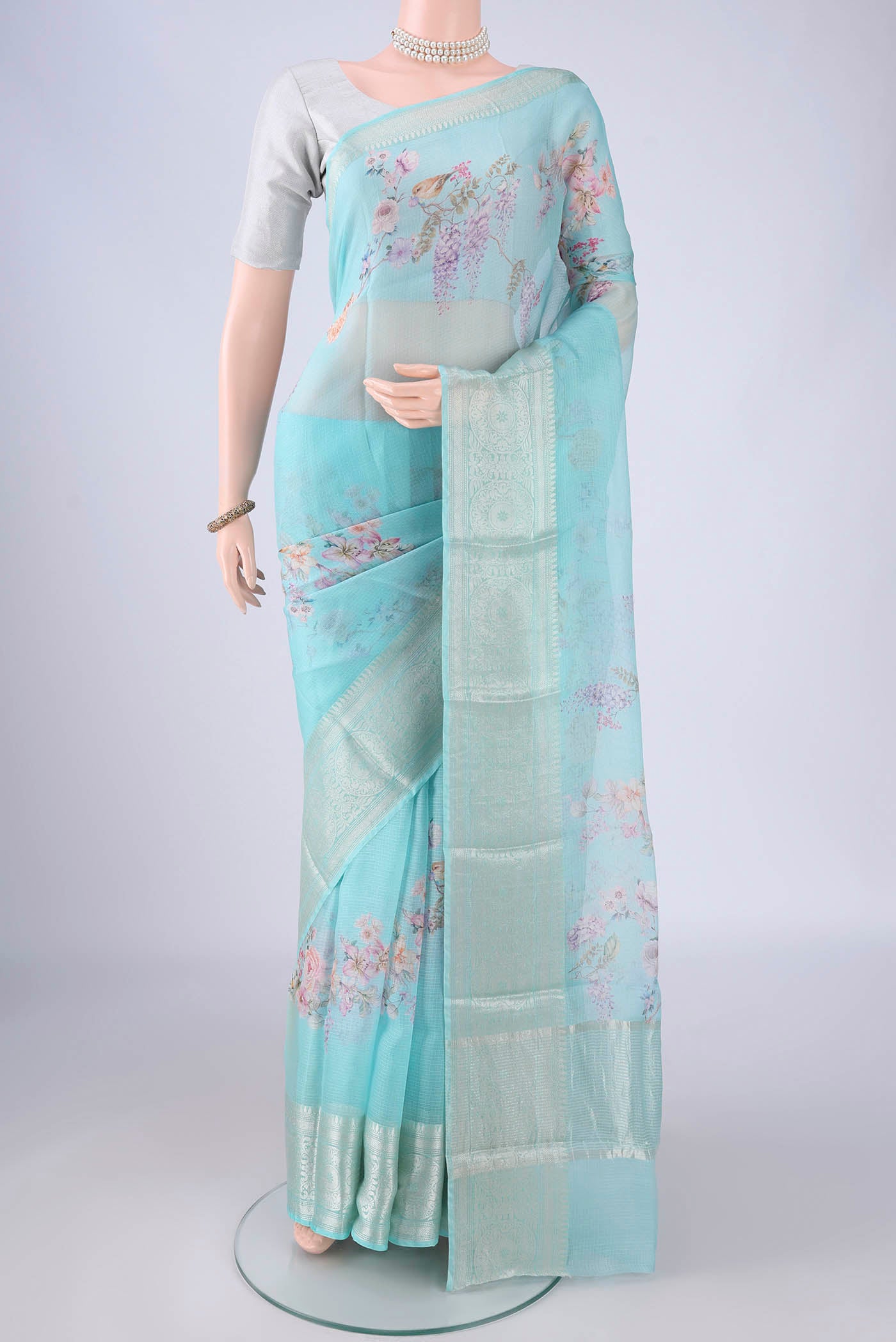 Sky Blue Kota Silk Saree with Floral Print on the body and Zari Border.  displayed on a mannequin