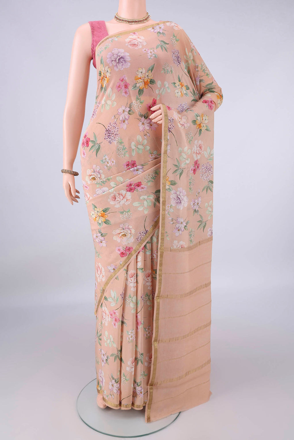 Peach Mysore Crepe Saree with Floral Print on the body and Zari Border.  displayed on a mannequin