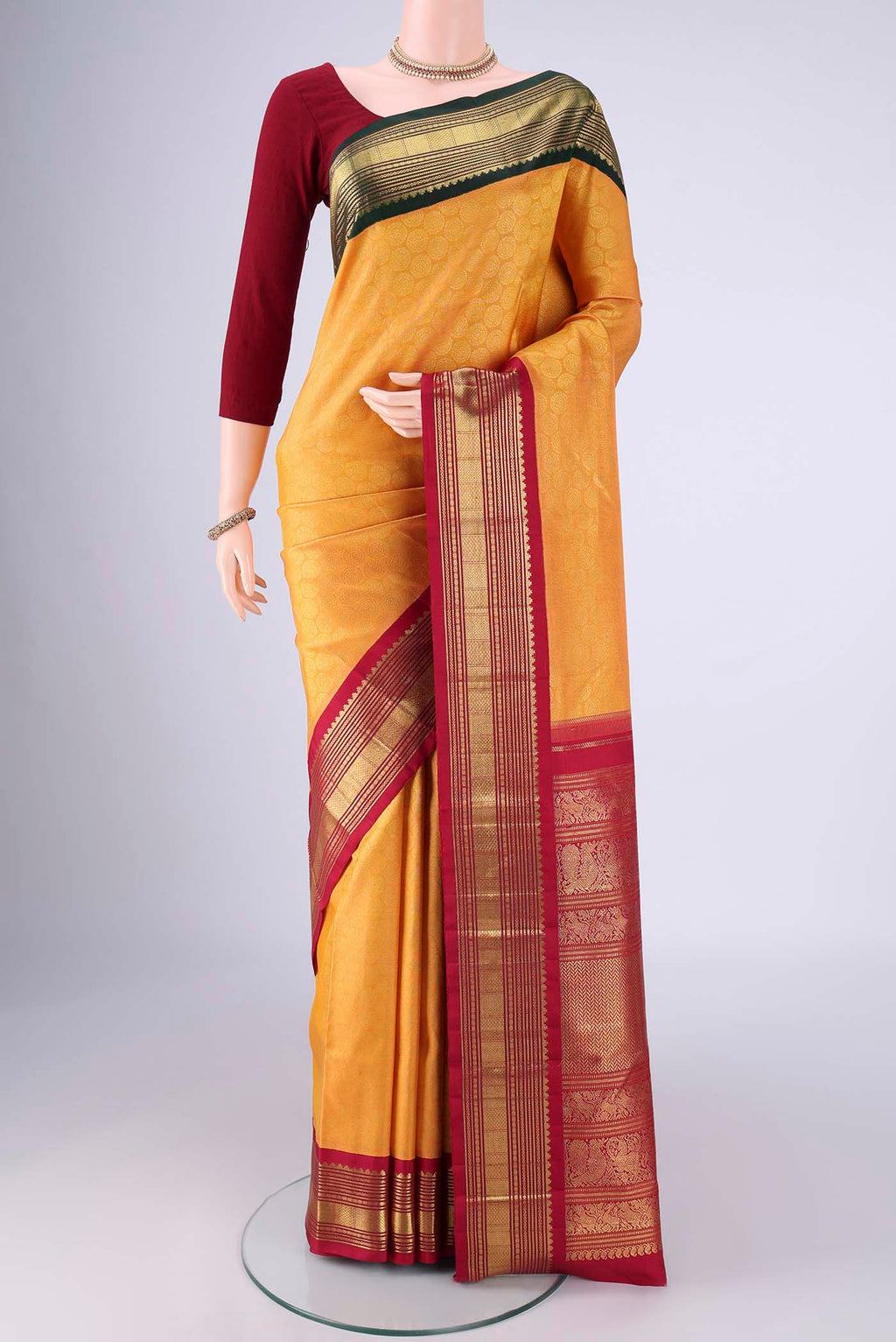 Pure Silk Pure Zari Yellow Kanjivaram Saree with Zari Brocade on the body and Ganga Jamuna Border.  displayed on a mannequin