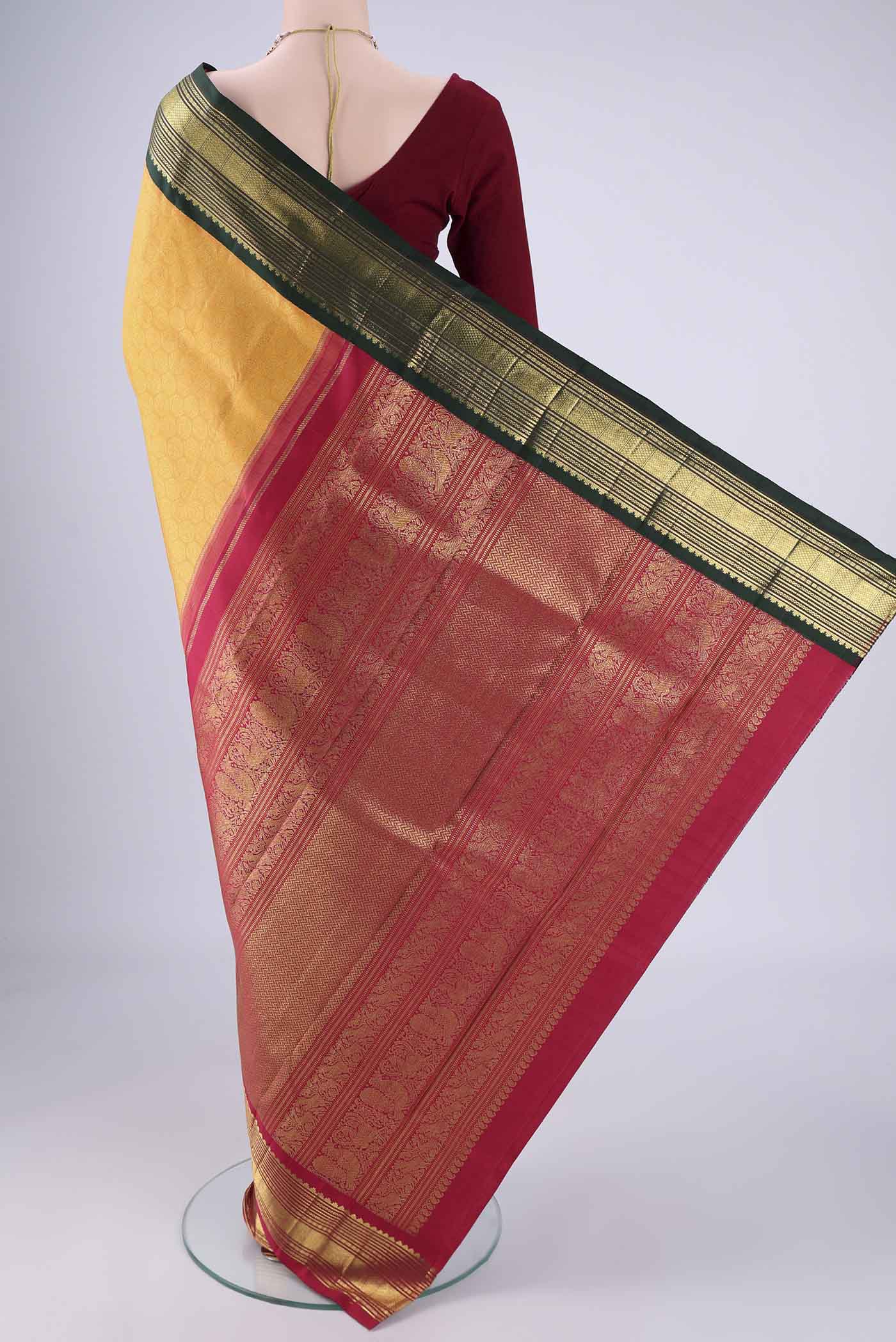 Flat view of Pure Silk Pure Zari Yellow Kanjivaram Saree with Zari Brocade on the body and Ganga Jamuna Border. 