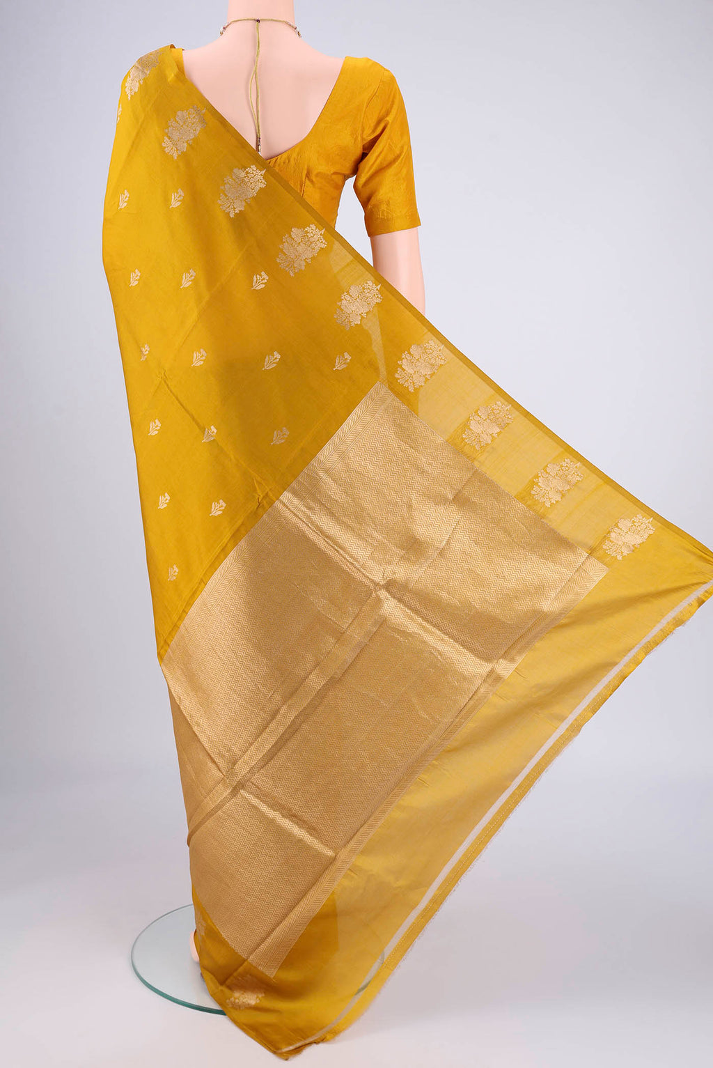 Flat view of Mustard Banarasi Katan Silk Saree with Zari Butta on the body and Plain Border. 