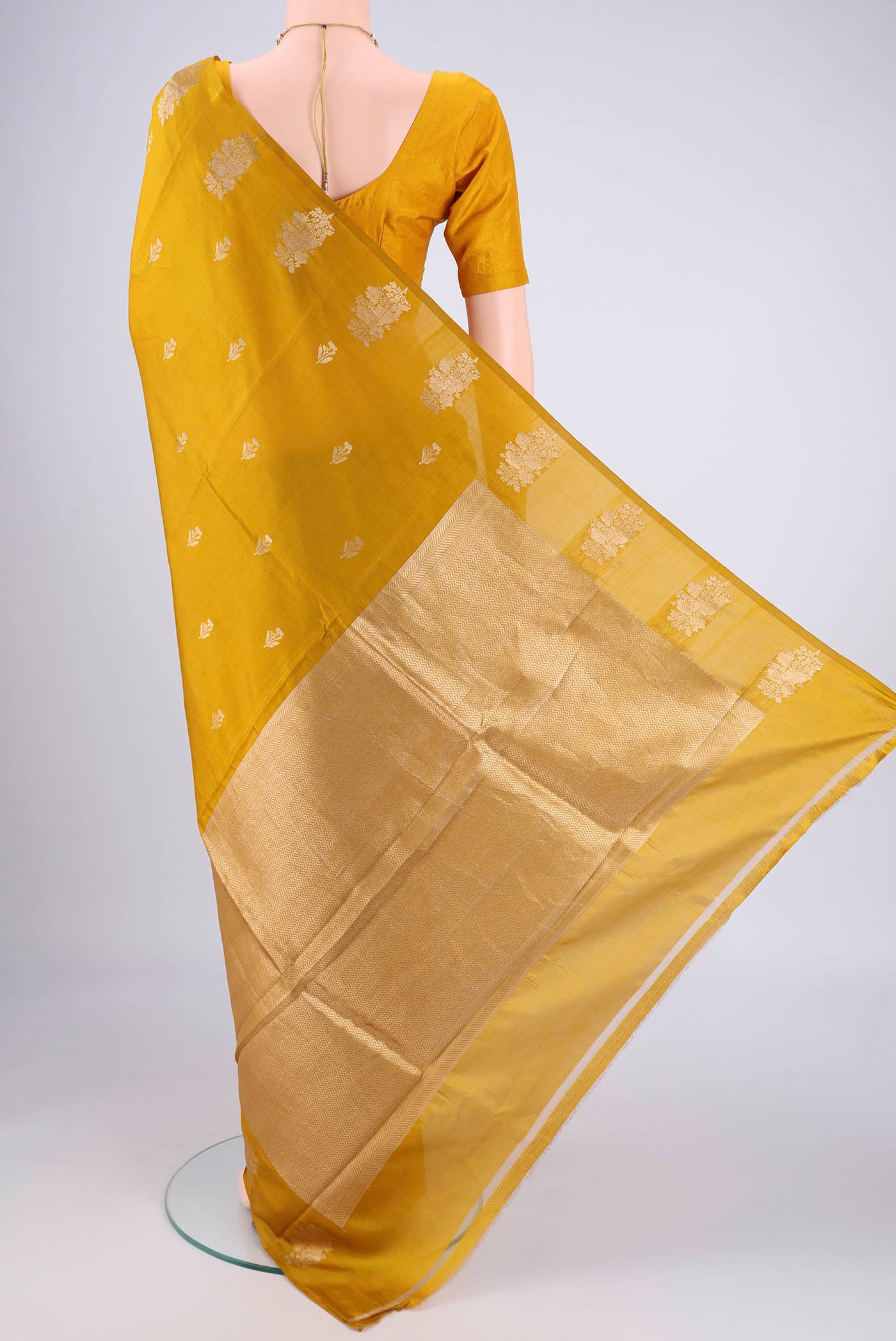 Flat view of Mustard Banarasi Katan Silk Saree with Zari Butta on the body and Plain Border. 