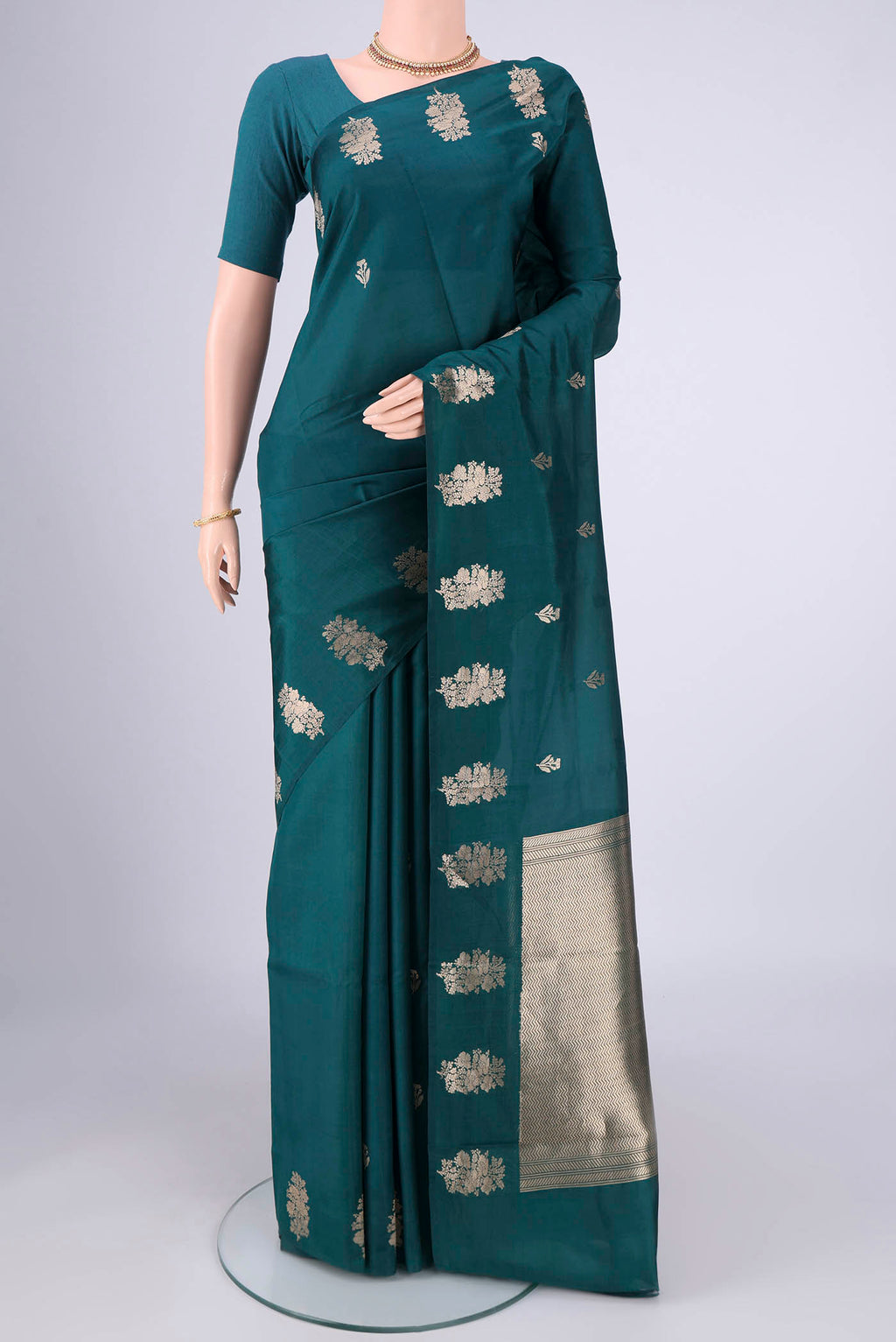 Teal Banarasi Katan Silk Saree with Zari Butta on the body and Plain Border.  displayed on a mannequin