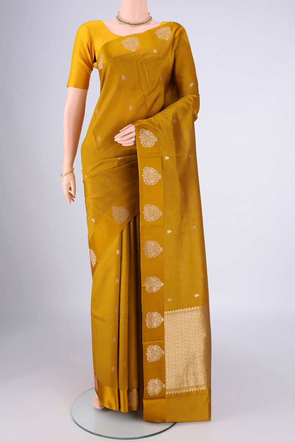 Mehandi Green Banarasi Katan Silk Saree with Zari Butta on the body and Satin Border.  displayed on a mannequin