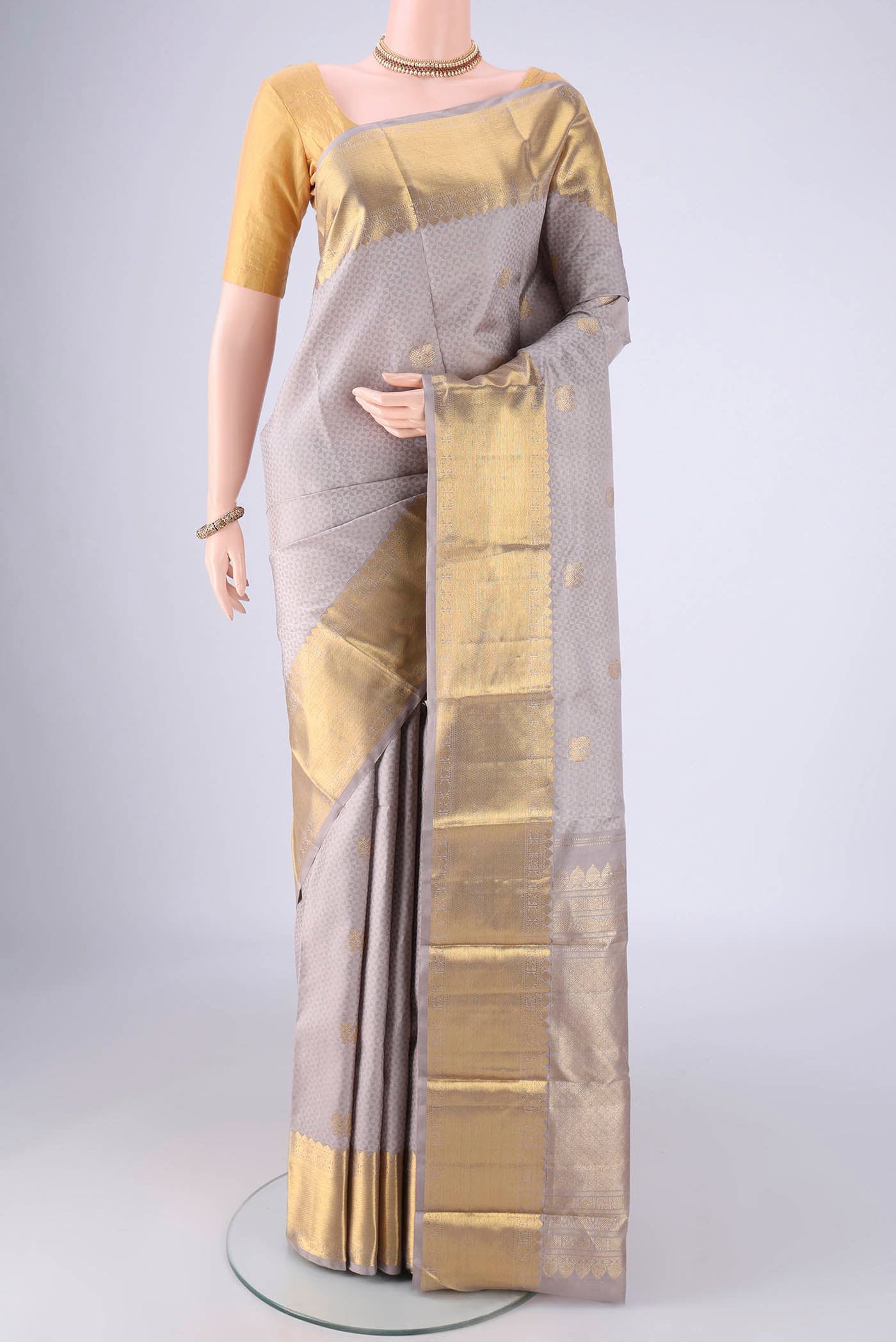Grey Kanjivaram Silk Saree with Jacquard With Zari Butta on the body and Zari Border.  displayed on a mannequin