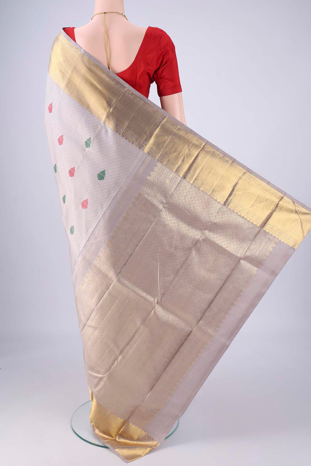 Flat view of Grey Kanjivaram Silk Saree with Jacquard With Thread Butta on the body and Zari Border. 