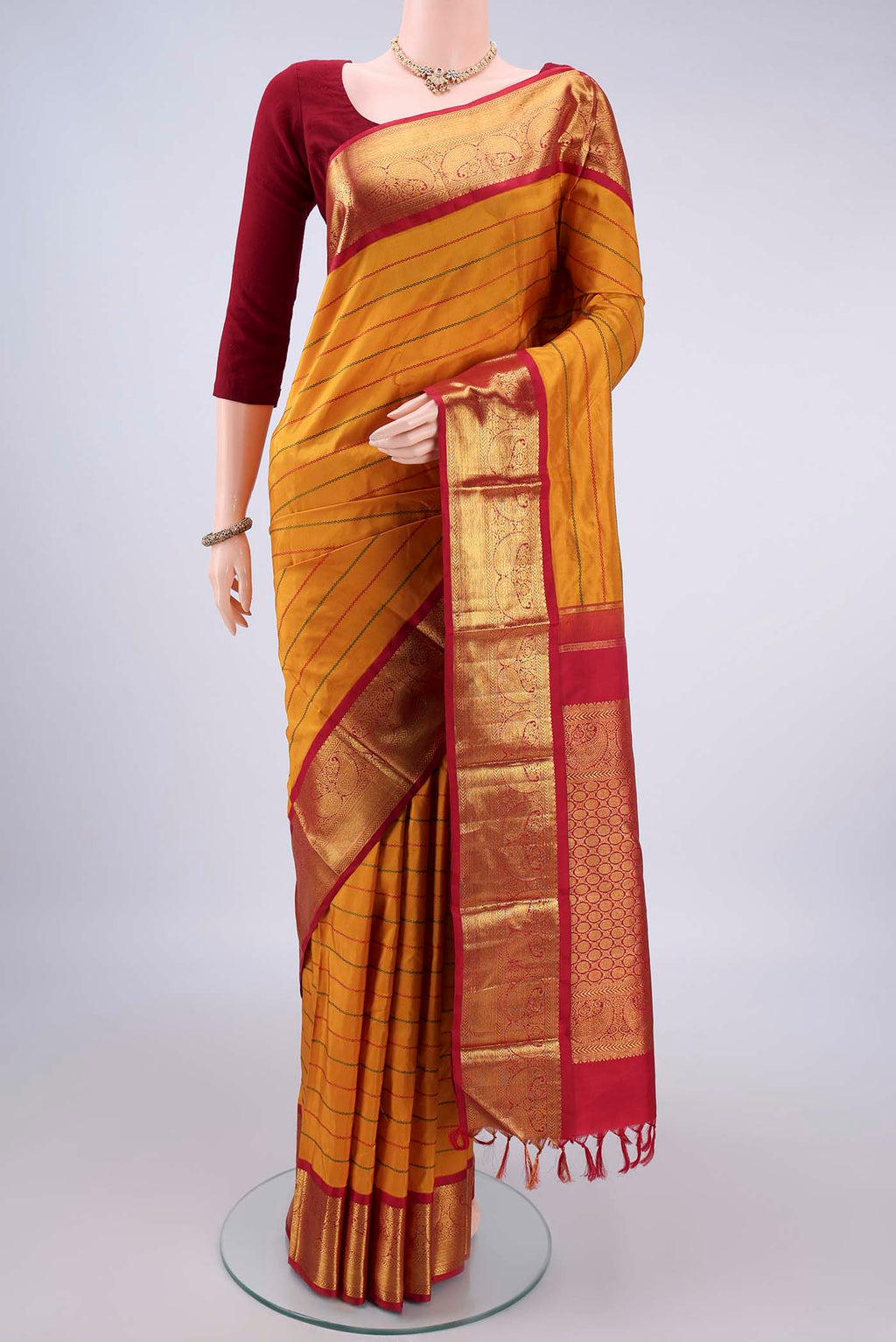 Pure Silk Mustard Kanjivaram Saree with Veldhari on the body and Zari Border.  displayed on a mannequin