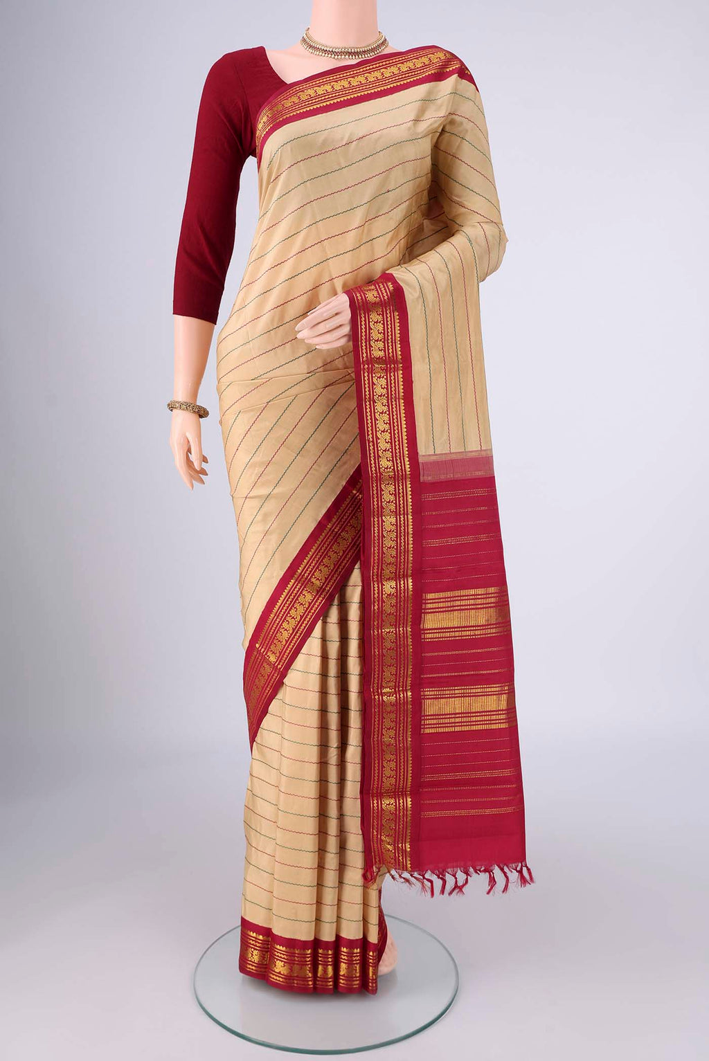 Beige Kanchipuram Silk Saree with Veldhari on the body and Zari Border.  displayed on a mannequin
