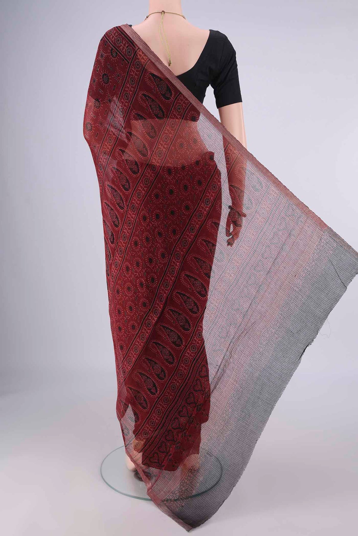 Flat view of Maroon Kota Cotton Saree with Ajrakh Print on the body and Zari Border. 