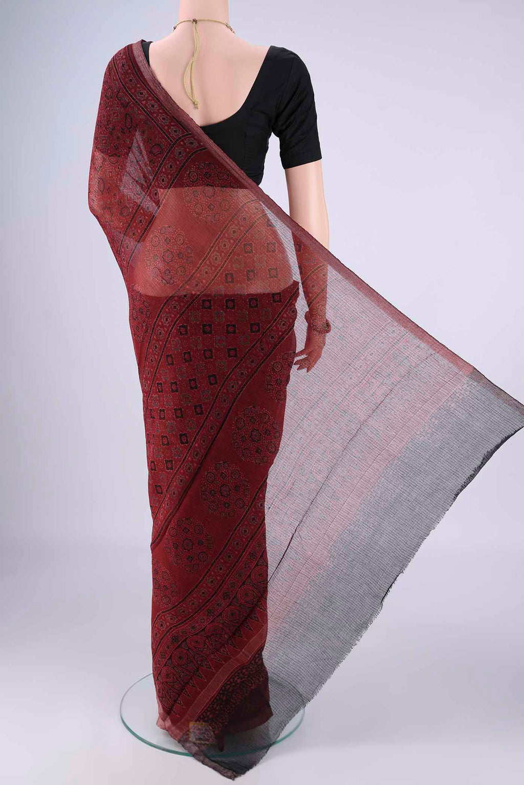 Flat view of Maroon Kota Cotton Saree with Ajrakh Print on the body and Zari Border. 