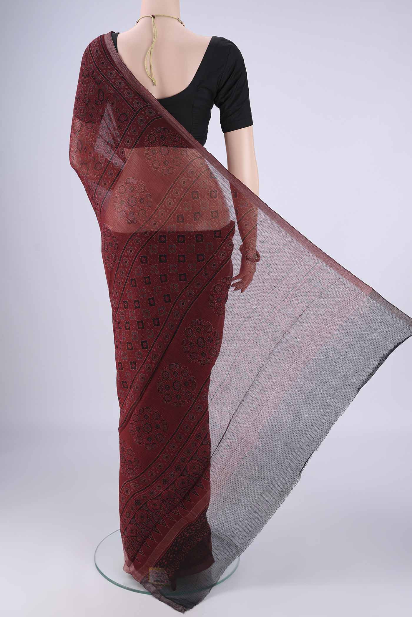 Flat view of Maroon Kota Cotton Saree with Ajrakh Print on the body and Zari Border. 