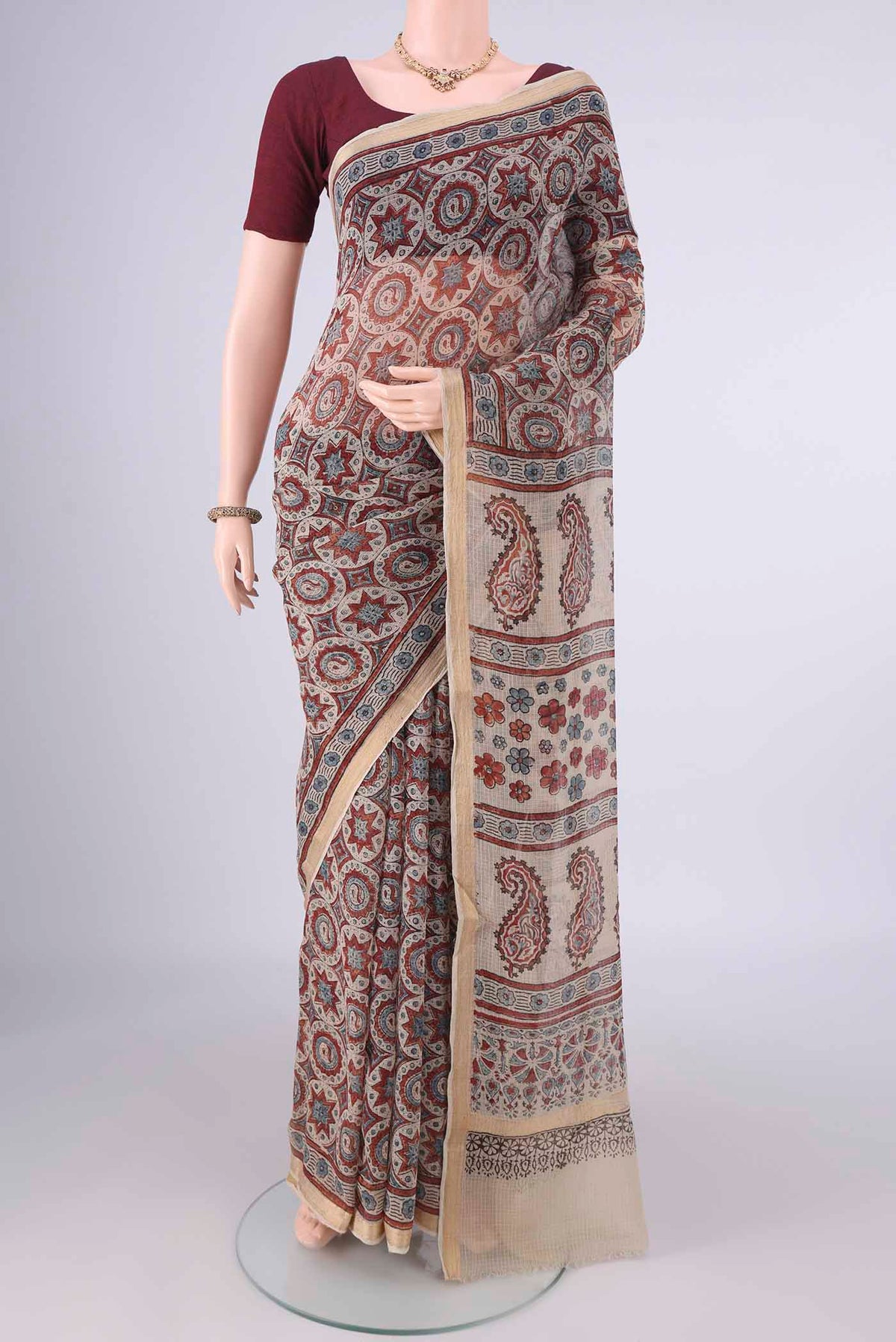 Beige Kota Cotton Saree with Ajrakh Print on the body and Zari Border.  displayed on a mannequin