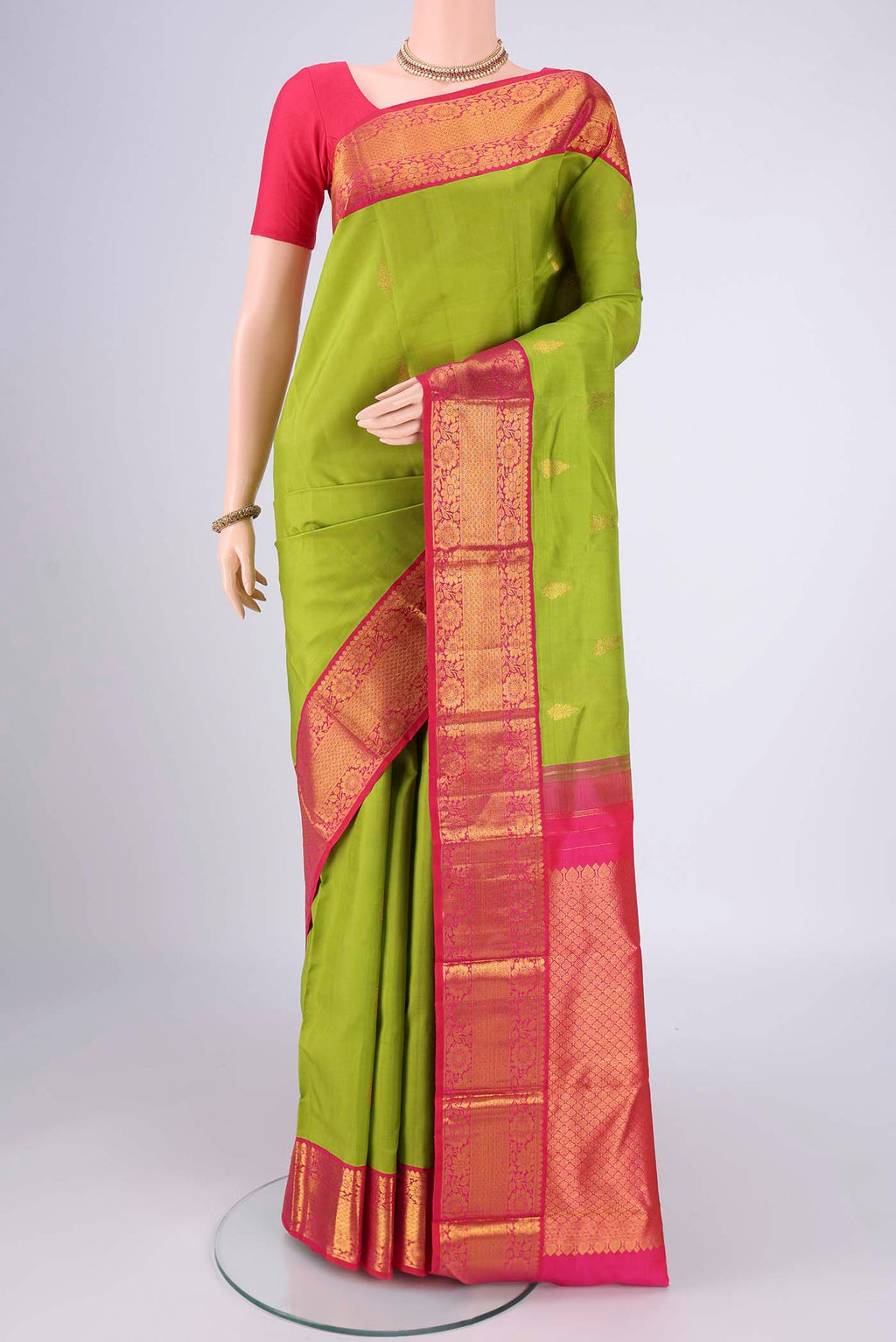 Green Kanjivaram Silk Saree with Zari Butta on the body and Zari Border.  displayed on a mannequin