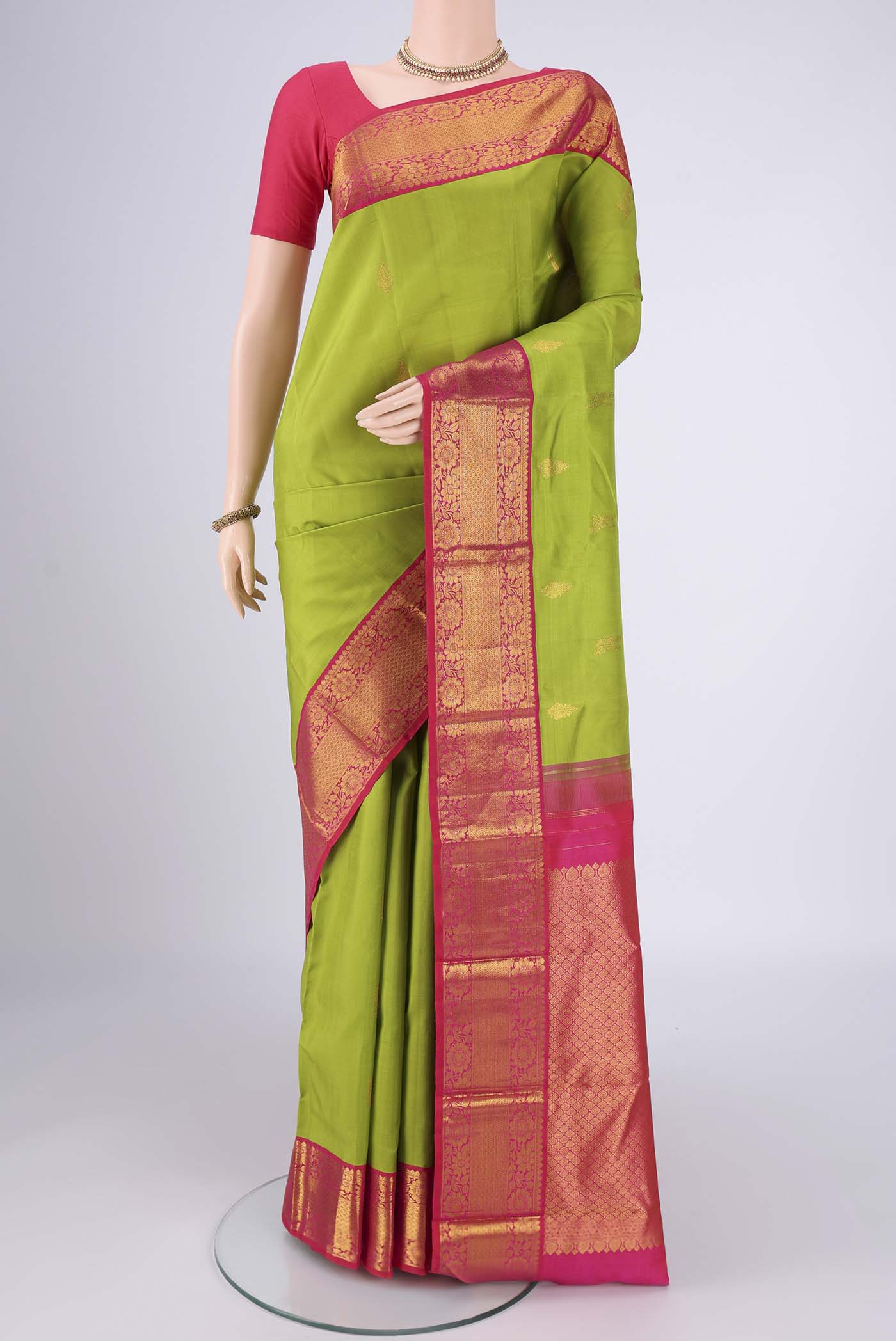 Green Kanjivaram Silk Saree with Zari Butta on the body and Zari Border.  displayed on a mannequin
