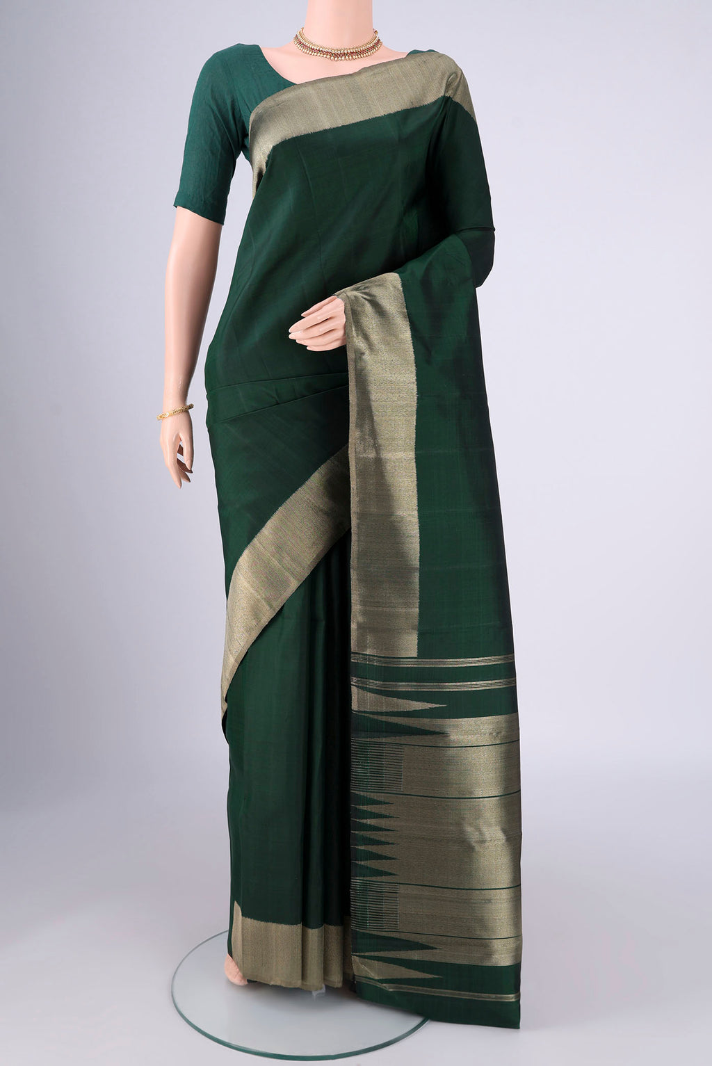 Bottle Green Kanjivaram Silk Saree with Plain Body and Zari Border.  displayed on a mannequin
