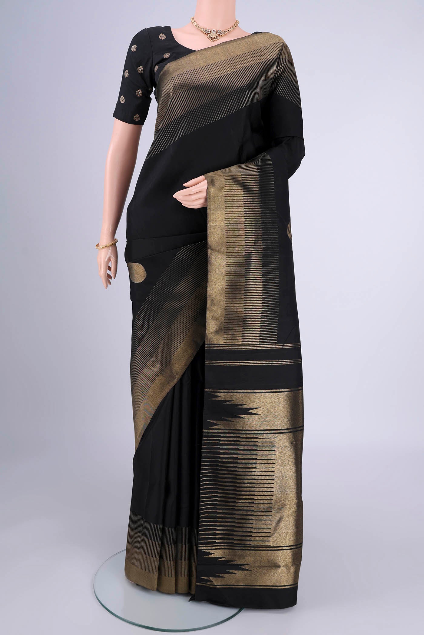 Black Kanchipuram Silk Saree with Zari Butta on the body and Zari Border.  displayed on a mannequin