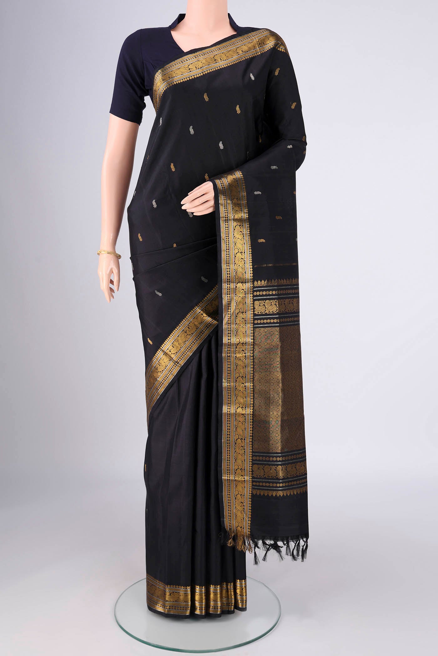 Black Kanchipuram Silk Saree with Zari And Thread Butta on the body and Zari Border.  displayed on a mannequin