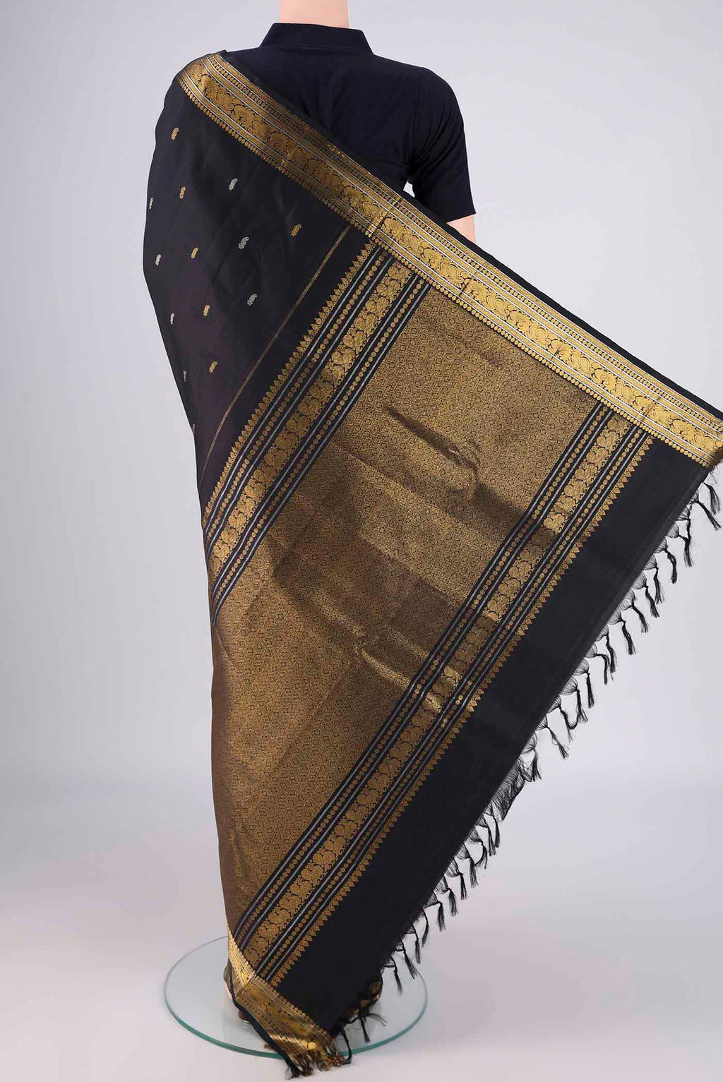 Flat view of Black Kanchipuram Silk Saree with Zari And Thread Butta on the body and Zari Border. 