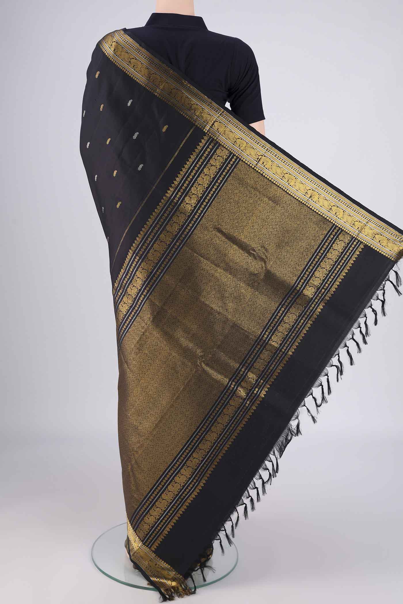 Flat view of Black Kanchipuram Silk Saree with Zari And Thread Butta on the body and Zari Border. 