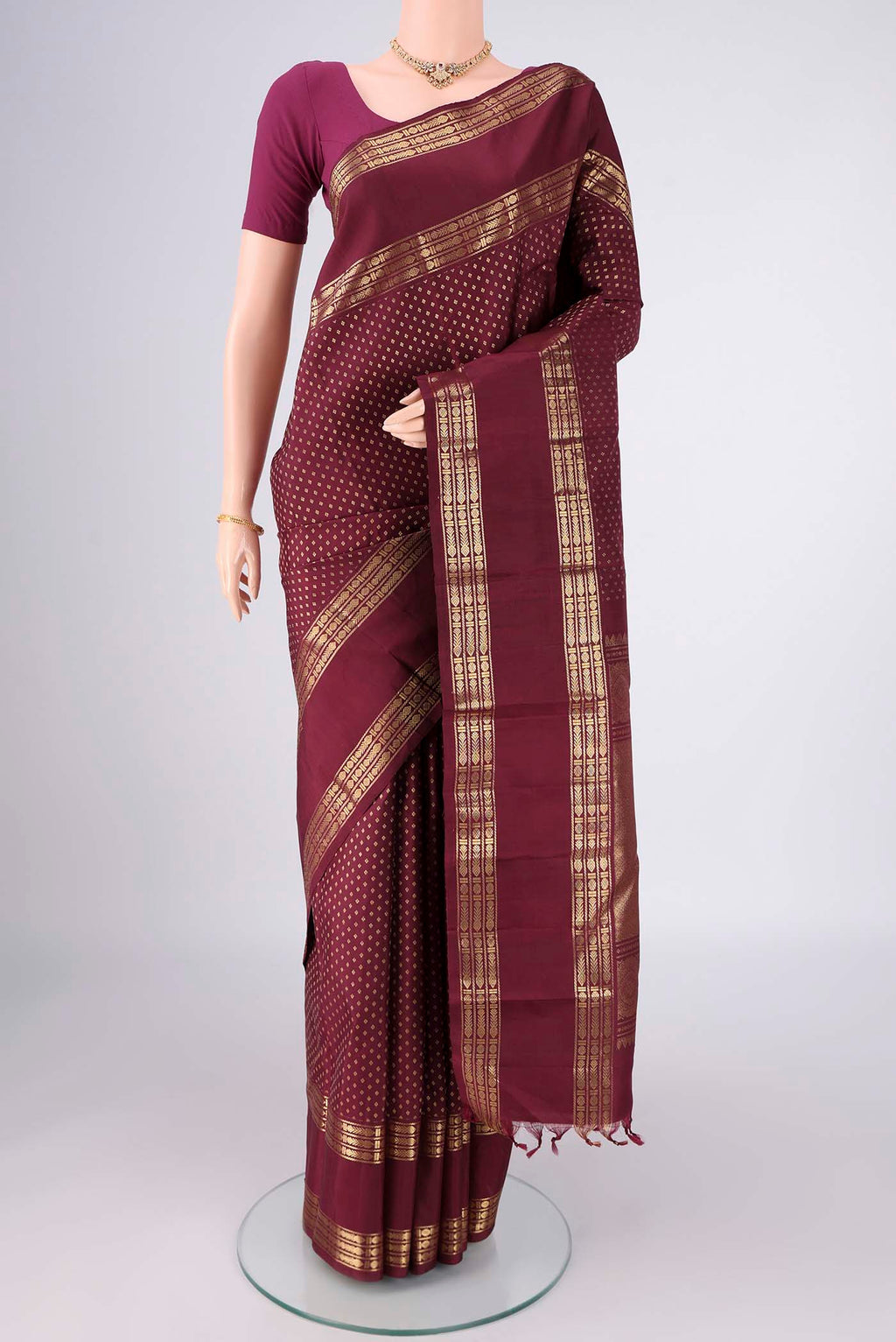 Pure Silk Pure Zari Maroon Kanjivaram Saree with Zari Butta on the body and Zari Border.  displayed on a mannequin