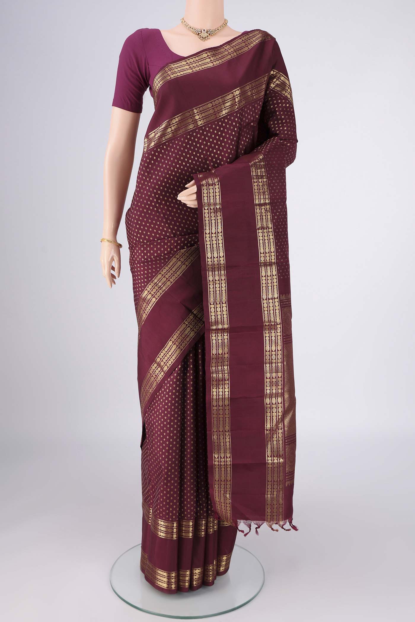 Pure Silk Pure Zari Maroon Kanjivaram Saree with Zari Butta on the body and Zari Border.  displayed on a mannequin