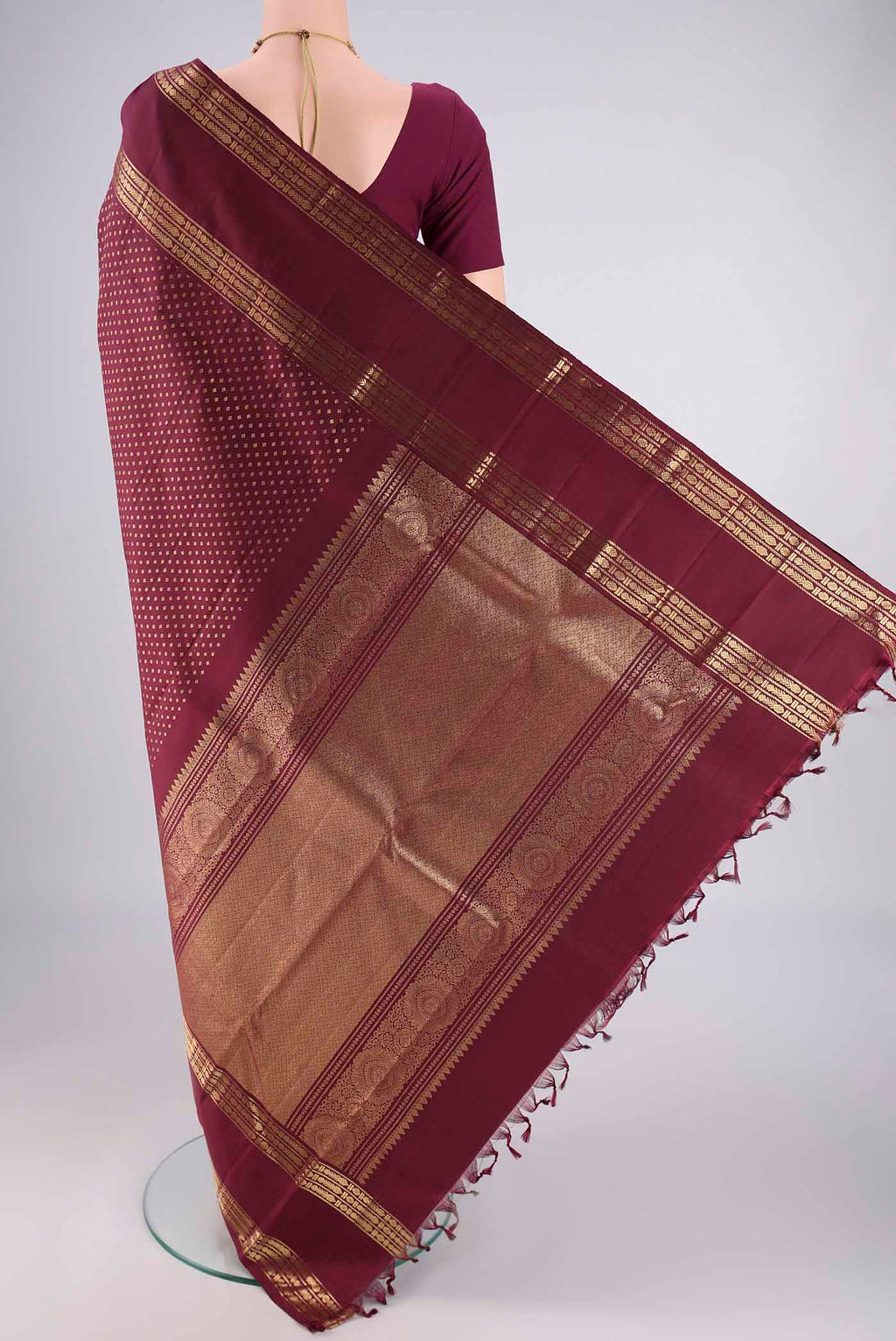 Flat view of Pure Silk Pure Zari Maroon Kanjivaram Saree with Zari Butta on the body and Zari Border. 