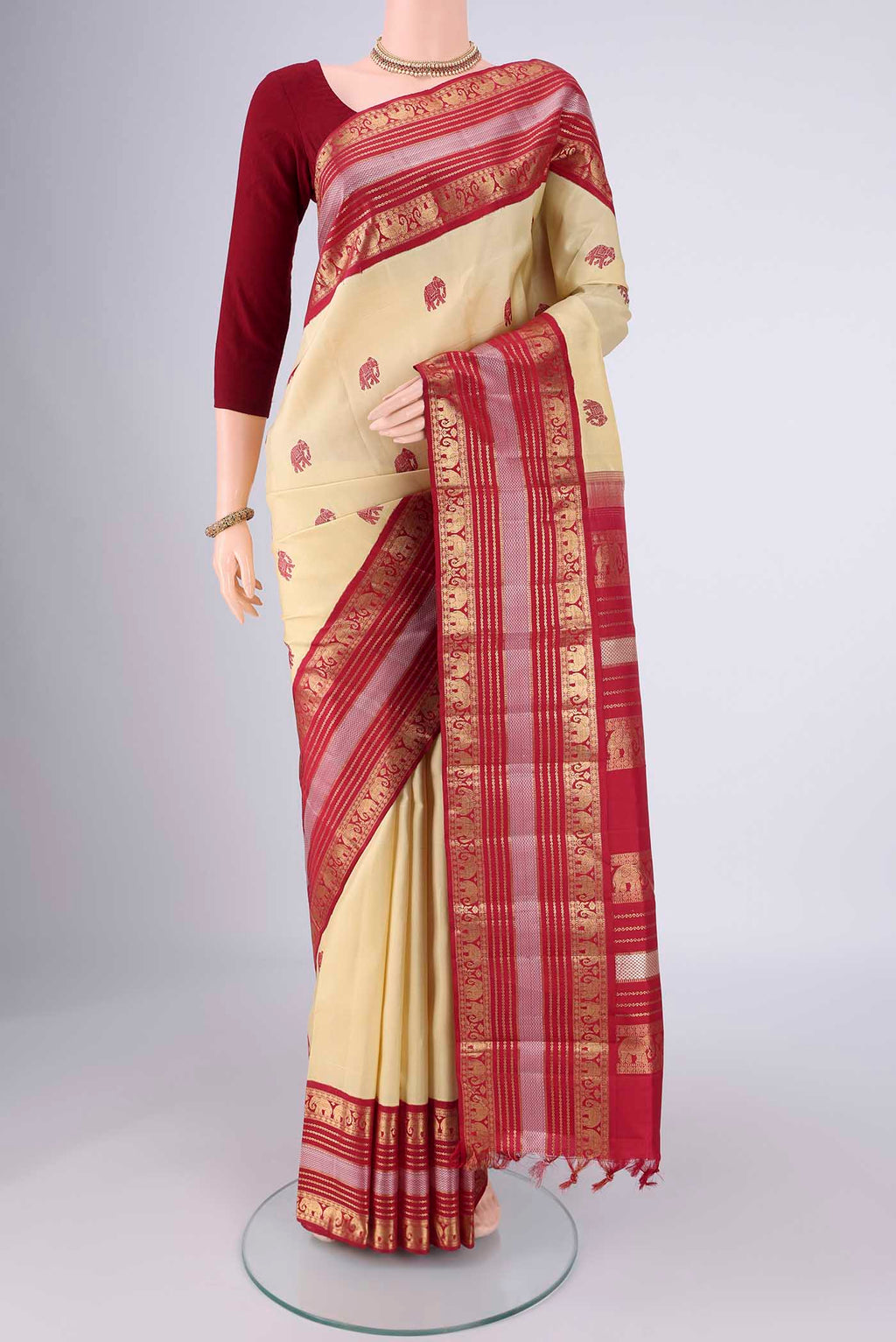 Sandal Kanchipuram Silk Saree with Thread Butta on the body and Zari Border.  displayed on a mannequin