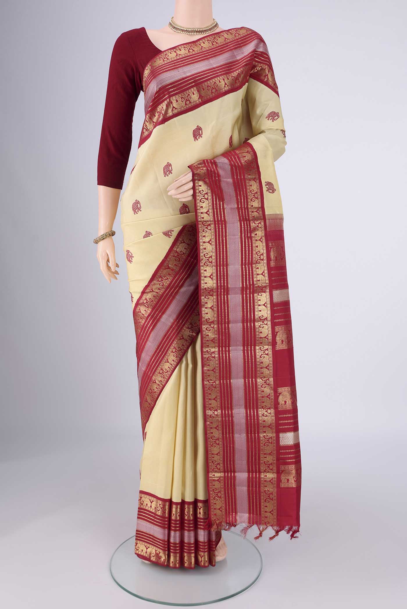 Sandal Kanchipuram Silk Saree with Thread Butta on the body and Zari Border.  displayed on a mannequin
