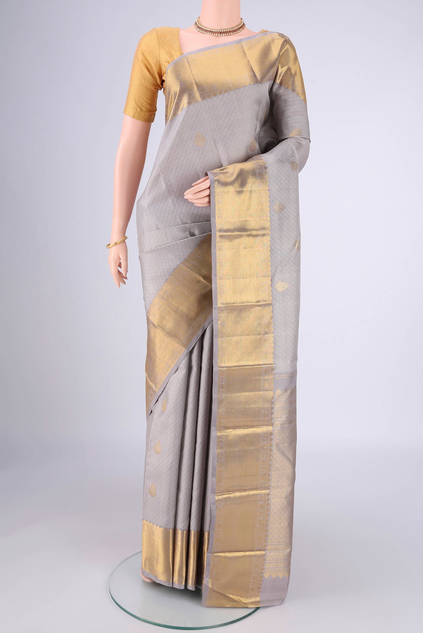 Grey Kanjivaram Silk Saree with Jacquard With Zari Butta on the body and Zari Border.  displayed on a mannequin