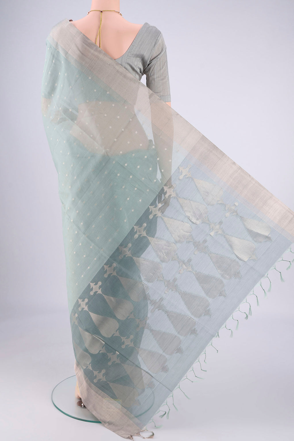 Flat view of Grey Silk Cotton Saree with Zari Butta on the body and Zari Border. 