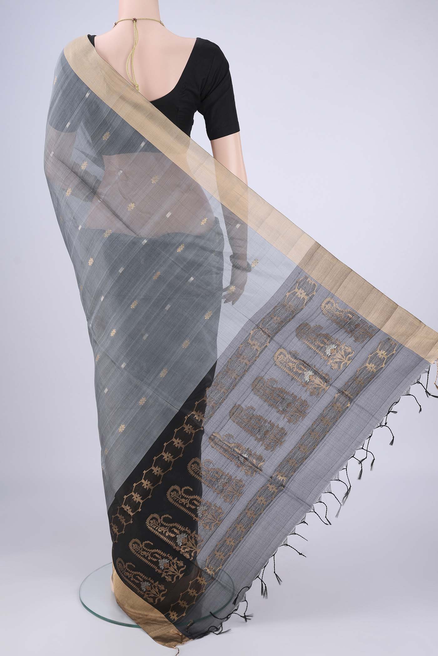 Flat view of Grey Silk Cotton Saree with Zari Butta on the body and Zari Border. 