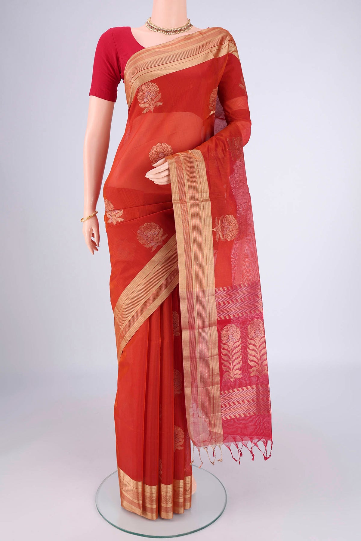 Orange Silk Cotton Saree with Zari Butta on the body and Zari Border.  displayed on a mannequin