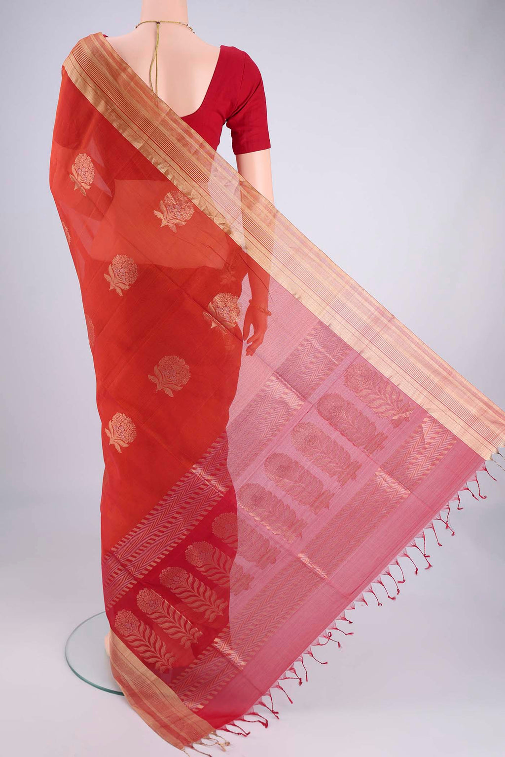 Flat view of Orange Silk Cotton Saree with Zari Butta on the body and Zari Border. 