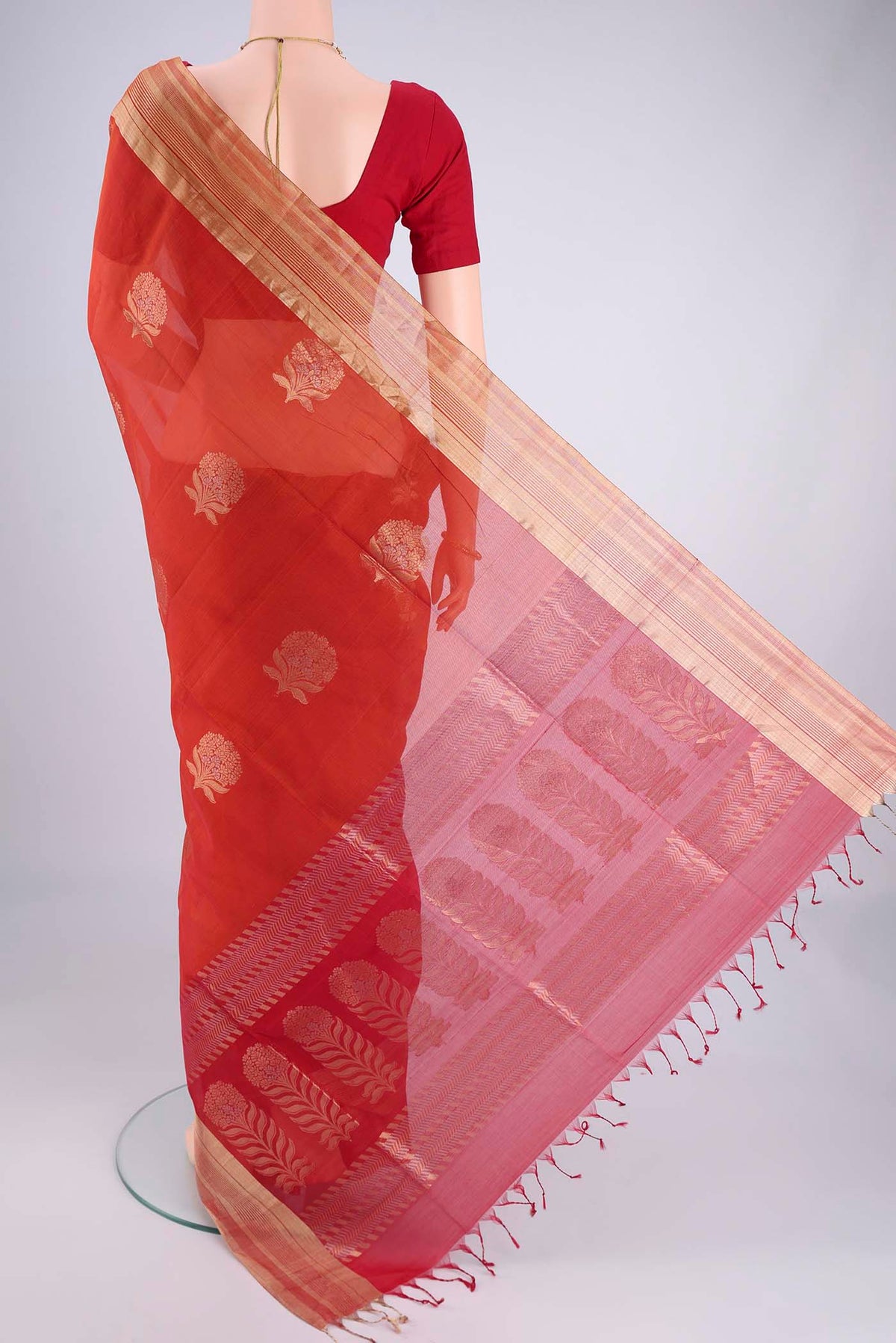 Flat view of Orange Silk Cotton Saree with Zari Butta on the body and Zari Border. 