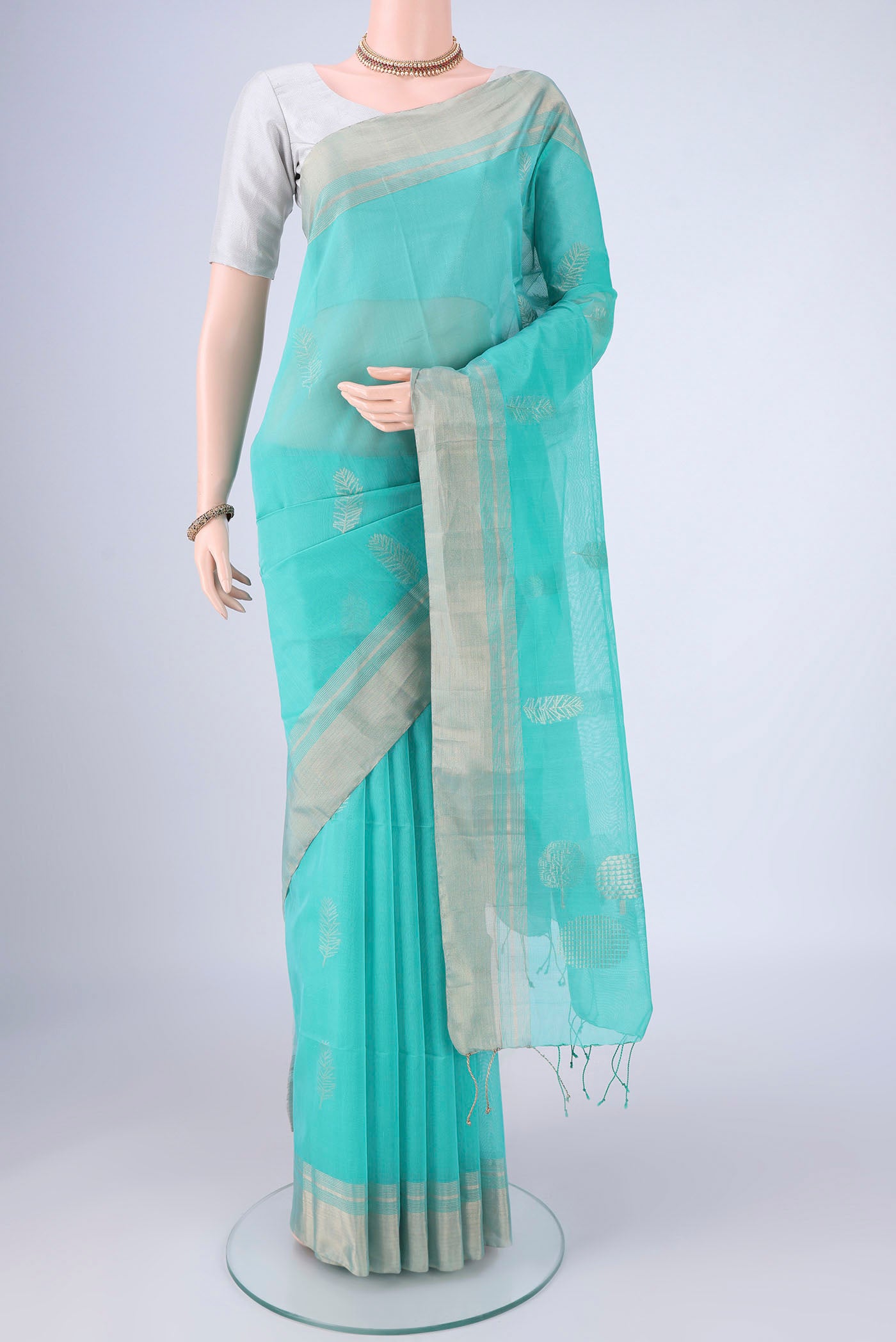 Light Blue Silk Cotton Saree with Zari Butta on the body and Zari Border.  displayed on a mannequin