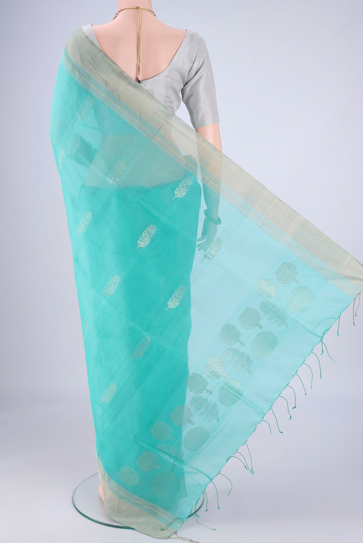Flat view of Light Blue Silk Cotton Saree with Zari Butta on the body and Zari Border. 