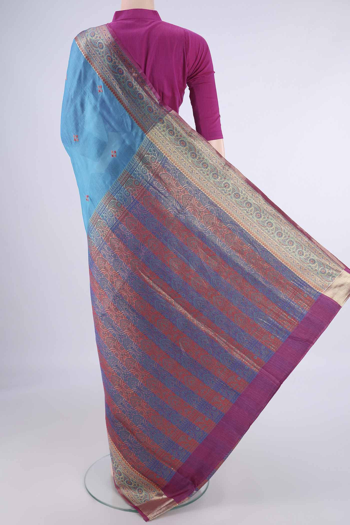 Flat view of Blue Banarasi Tussar Silk Saree with Embroidery on the body and Zari Border. 