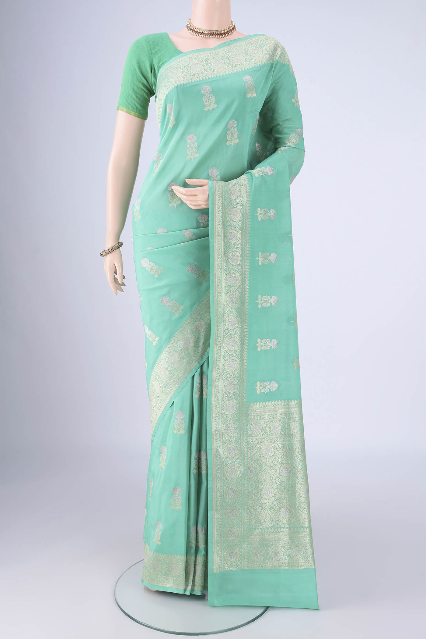 Sea Green Banarasi Silk Saree with Zari Butta on the body and Zari Border.  displayed on a mannequin