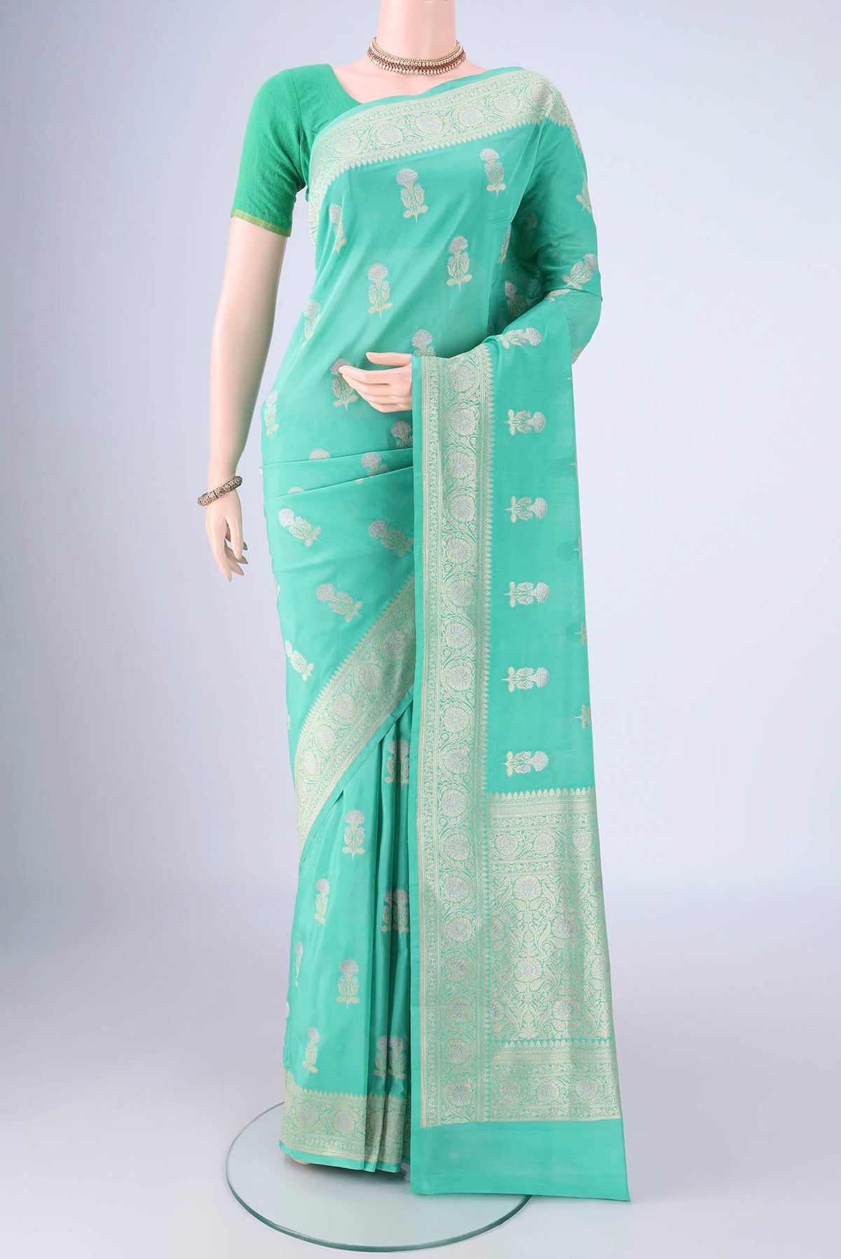 Sea Green Banarasi Silk Saree with Zari Butta on the body and Zari Border.  displayed on a mannequin