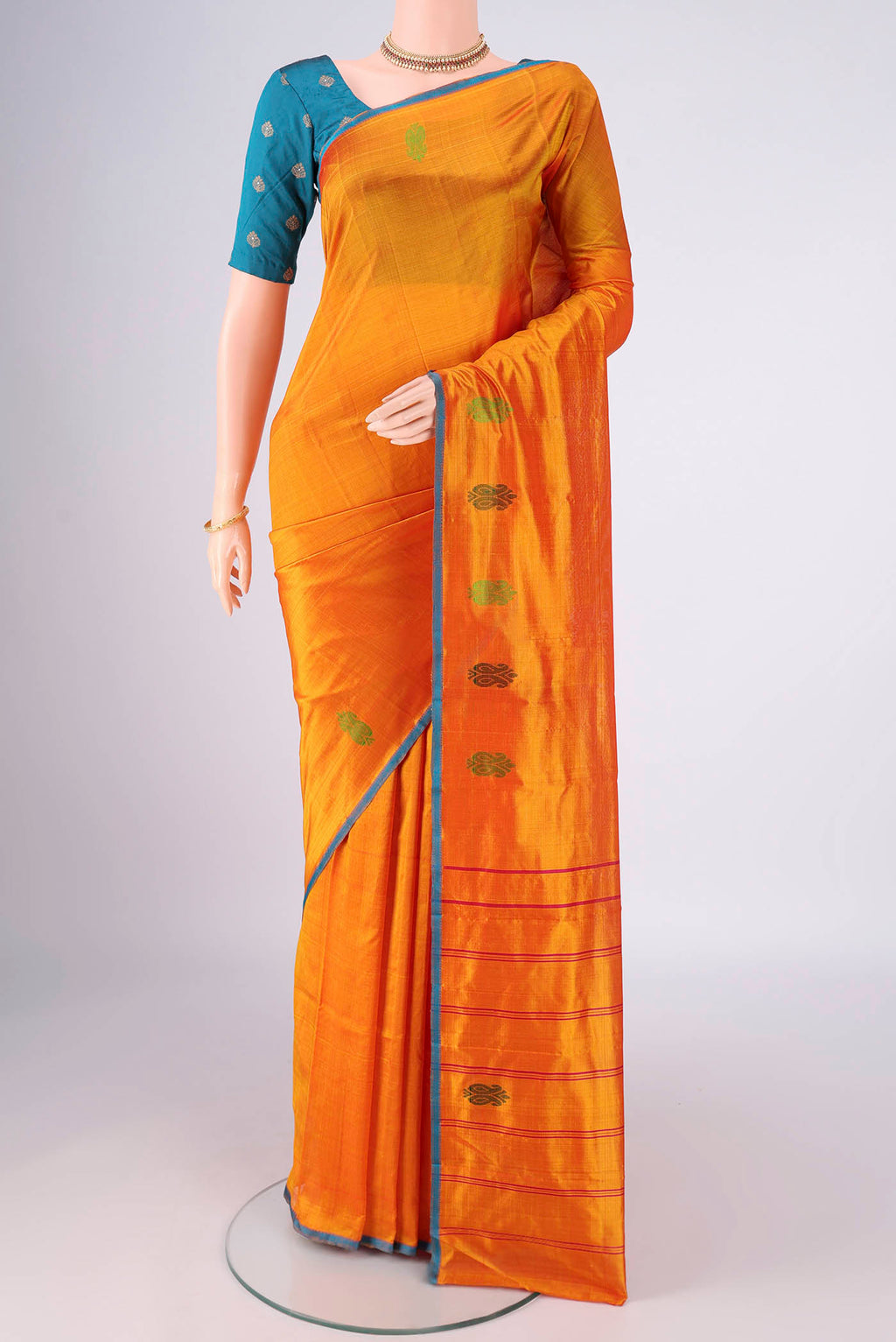 Orange Kanchipuram Silk Saree with Plain Body and Thread Border.  displayed on a mannequin