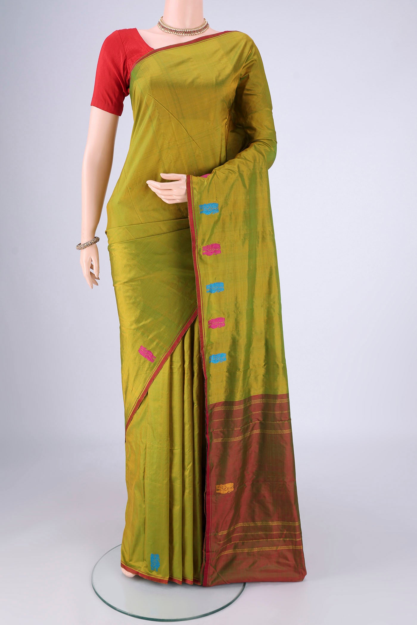 Mehandi Green Dual Tone Kanchipuram Silk Saree with Plain Body and Thread Border.  displayed on a mannequin