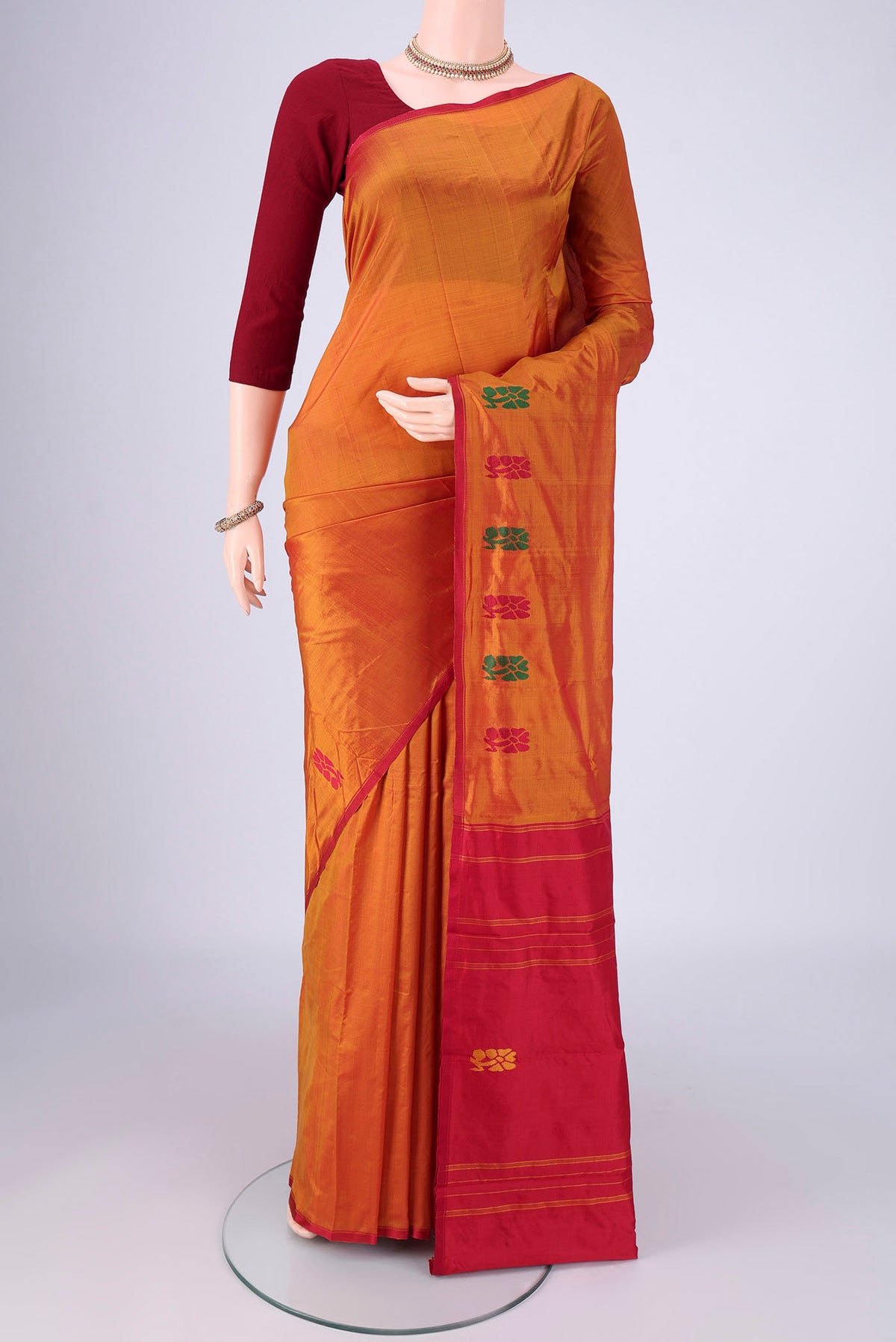 Rust Kanchipuram Silk Saree with Plain Body and Thread Border.  displayed on a mannequin